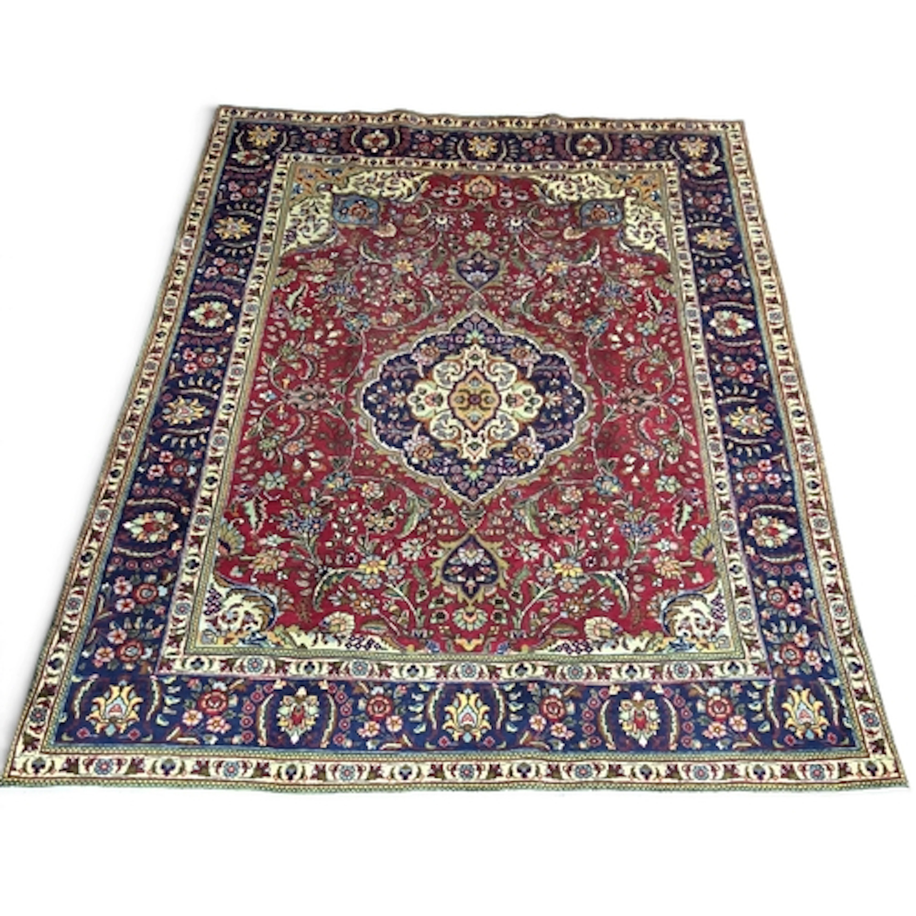 A hand-woven Persian Tabriz carpet, decorated with a traditi...