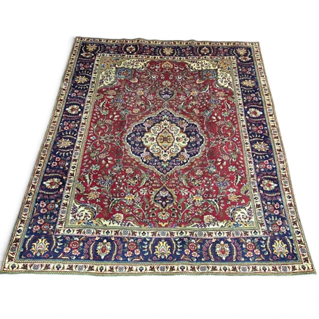 A hand-woven Persian Tabriz carpet, decorated with a traditi...
