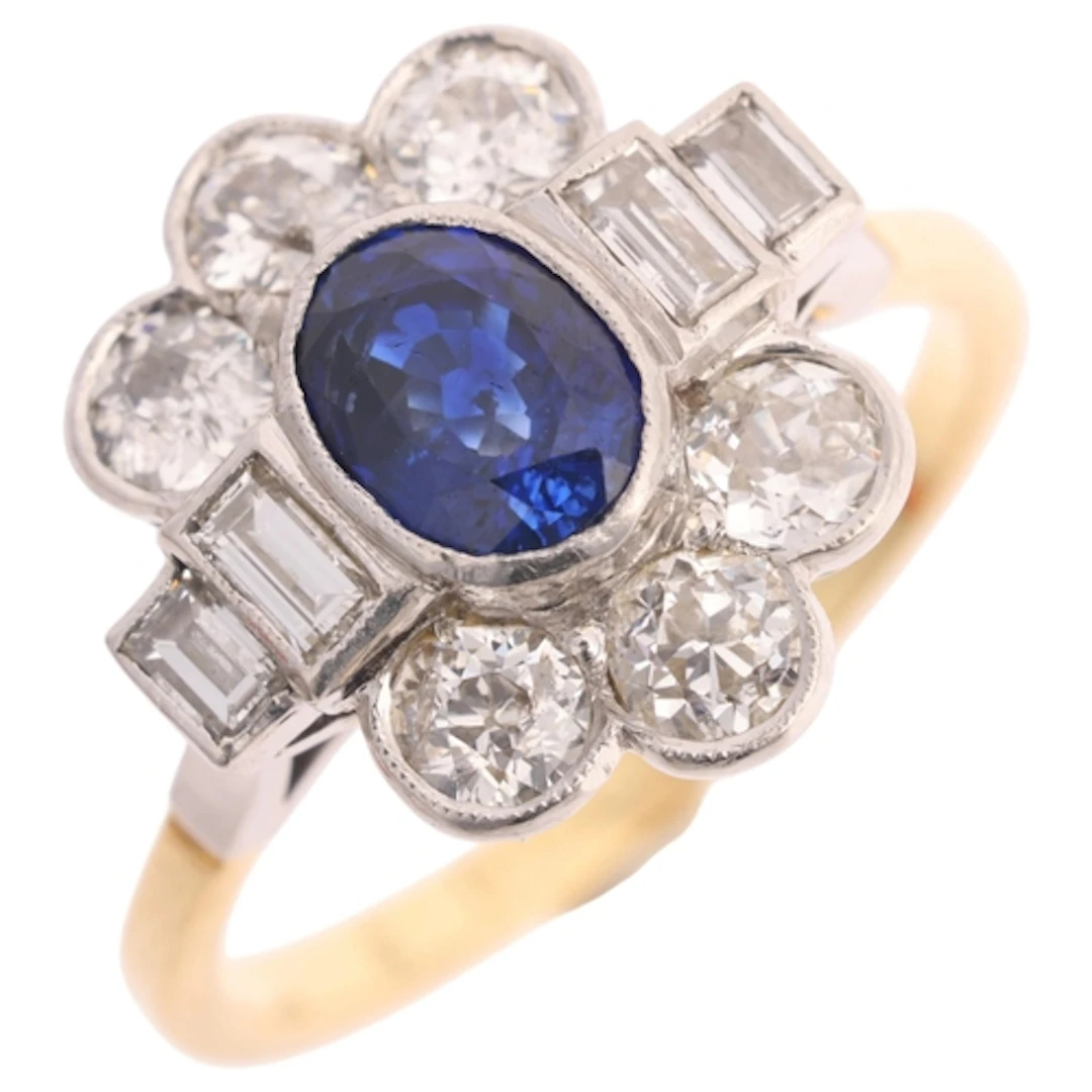 An 18ct gold sapphire and diamond cluster ring, platinum-top...