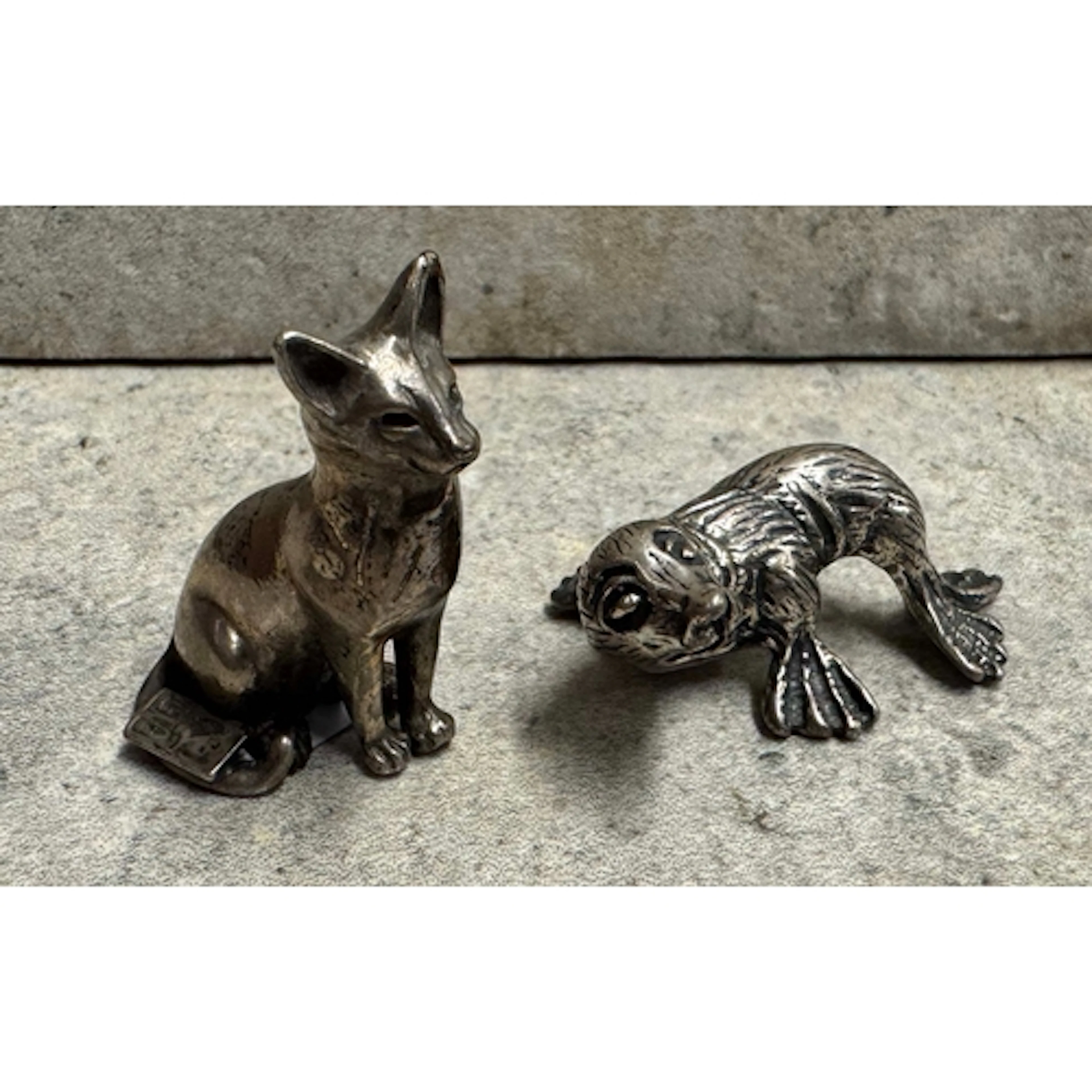 A Continental silver figure of a cat together with another s...