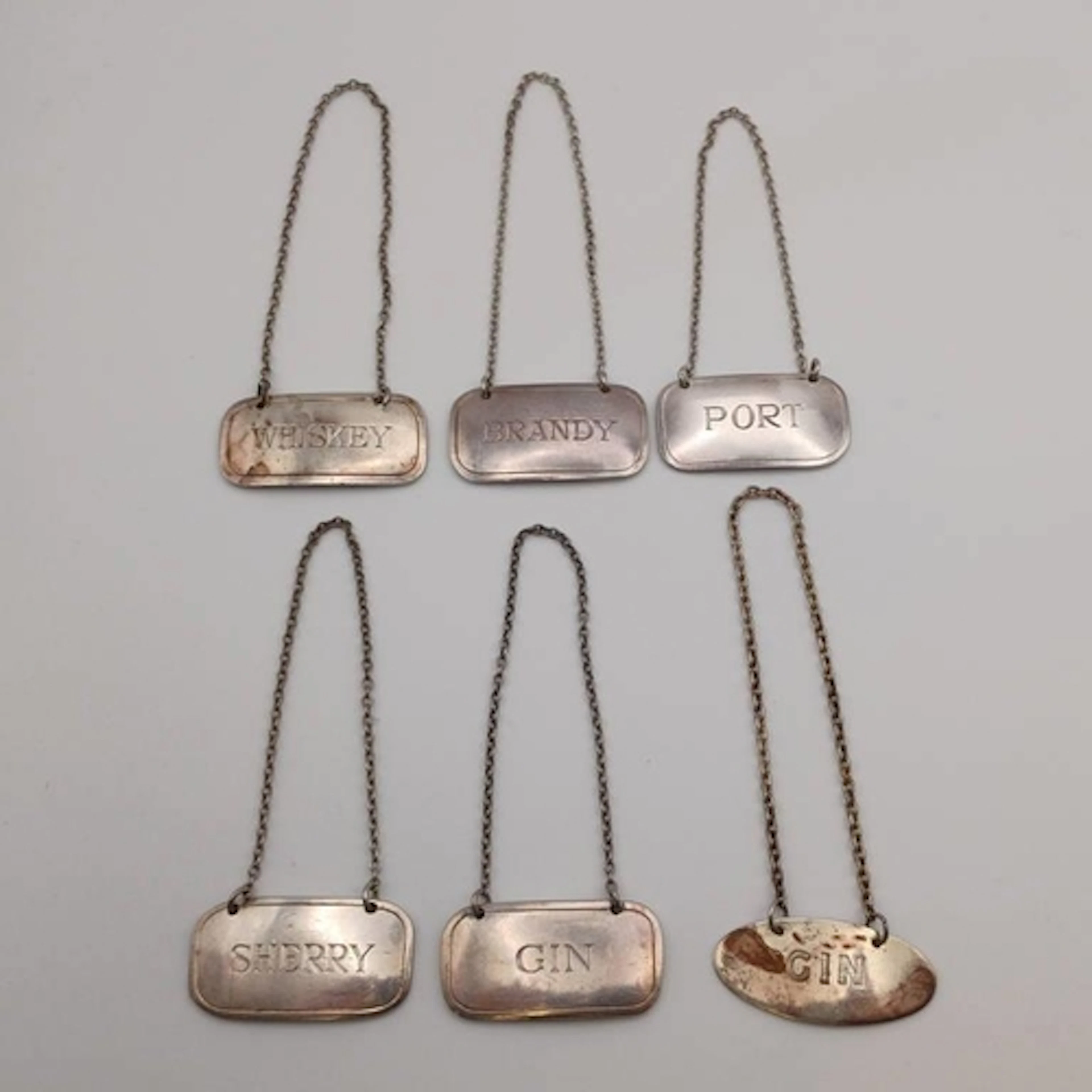 A SET OF 5 DECANTER LABELS MARKED STERLING SILVER & 1 OTHER ...