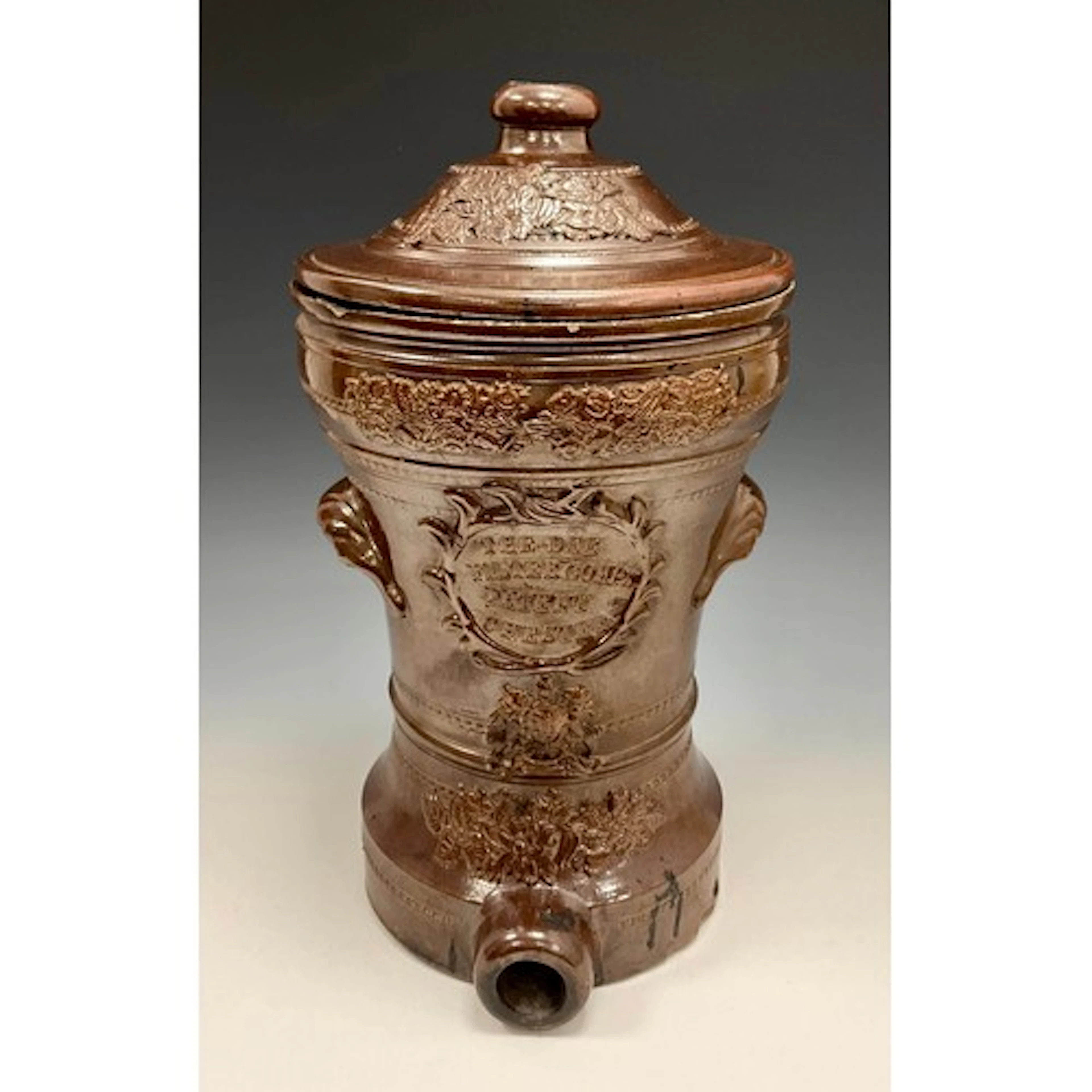 A Derbyshire brown salt glazed stoneware water filter and co...