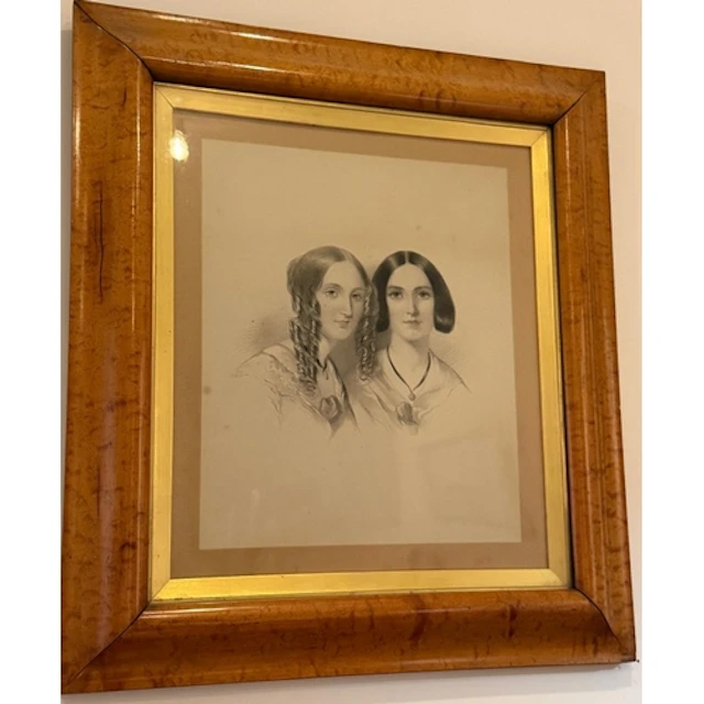 A framed portrait of two young women in period dress.