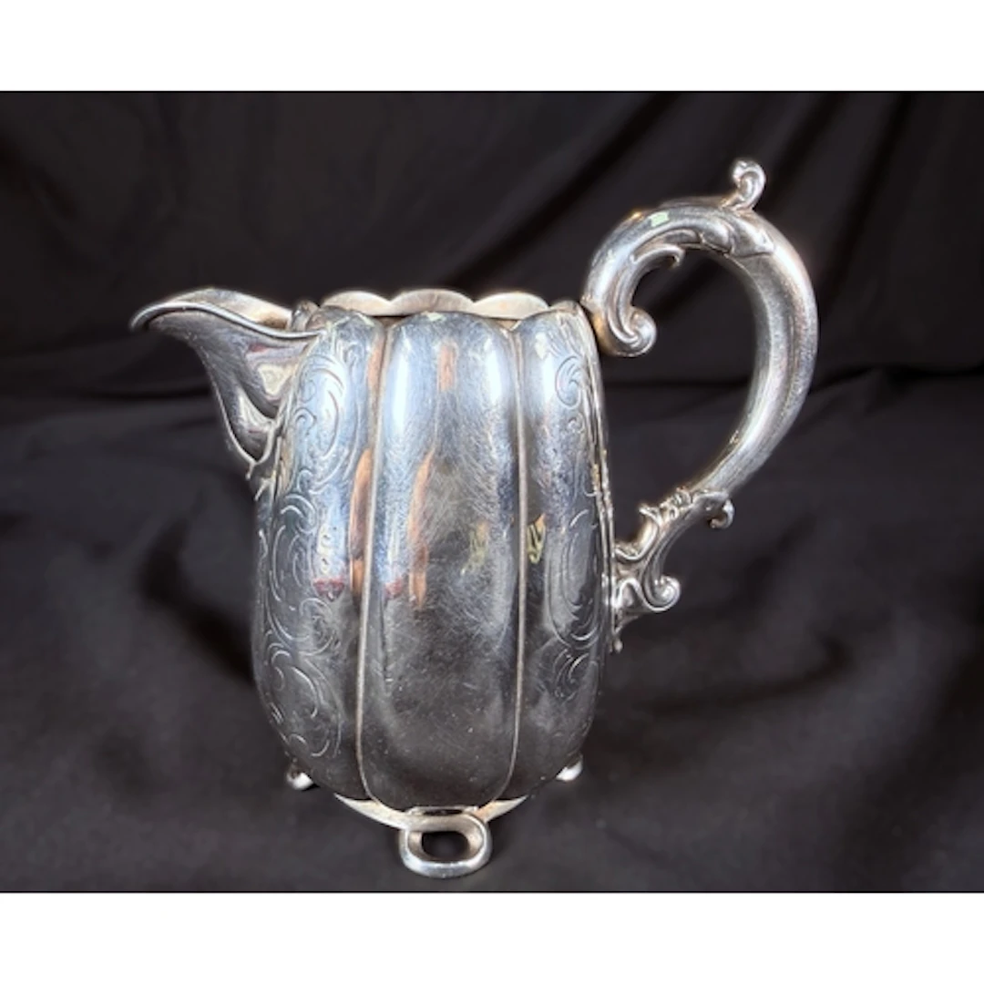 A 19th century Dutch silver lobed milk jug on four feet with...