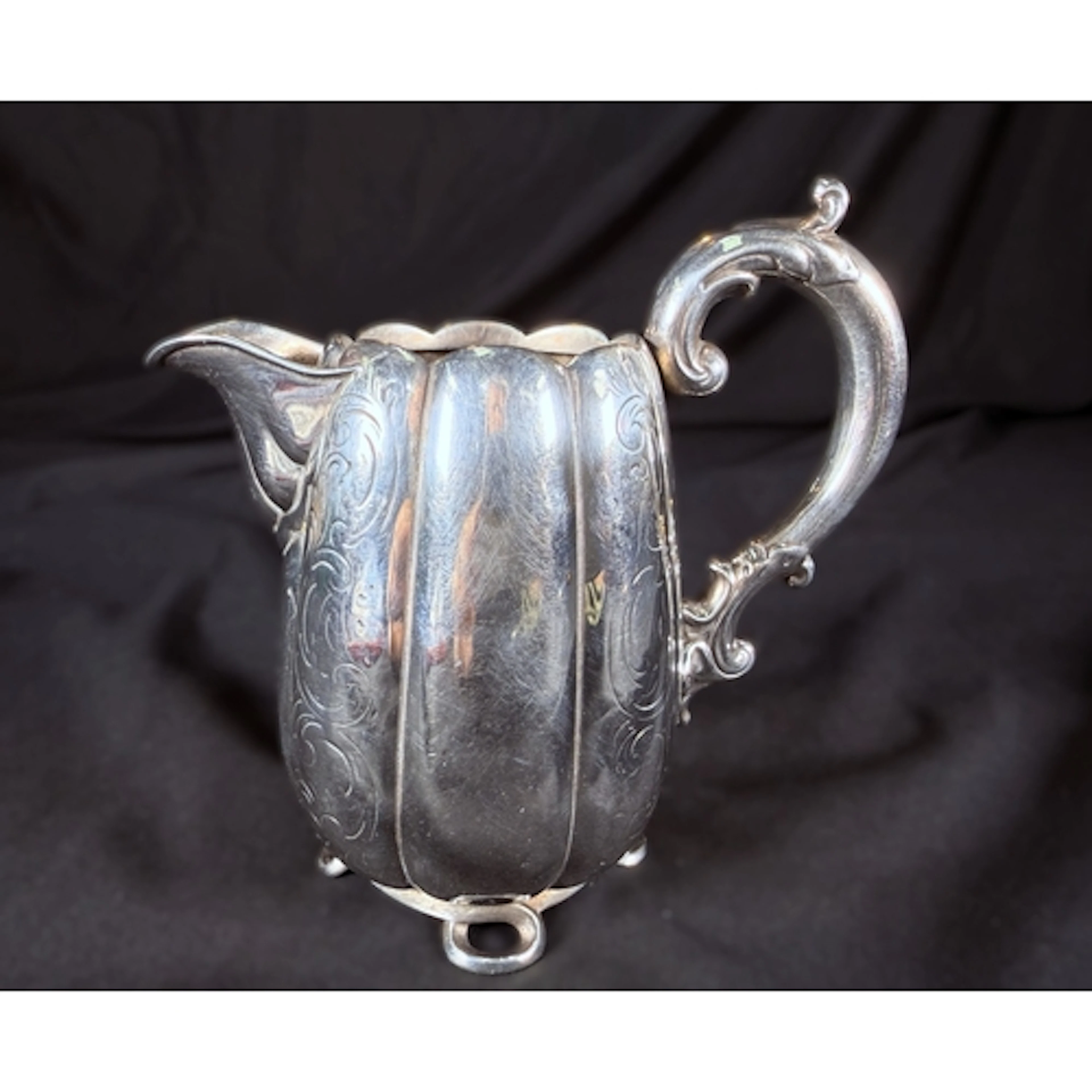 A 19th century Dutch silver lobed milk jug on four feet with...
