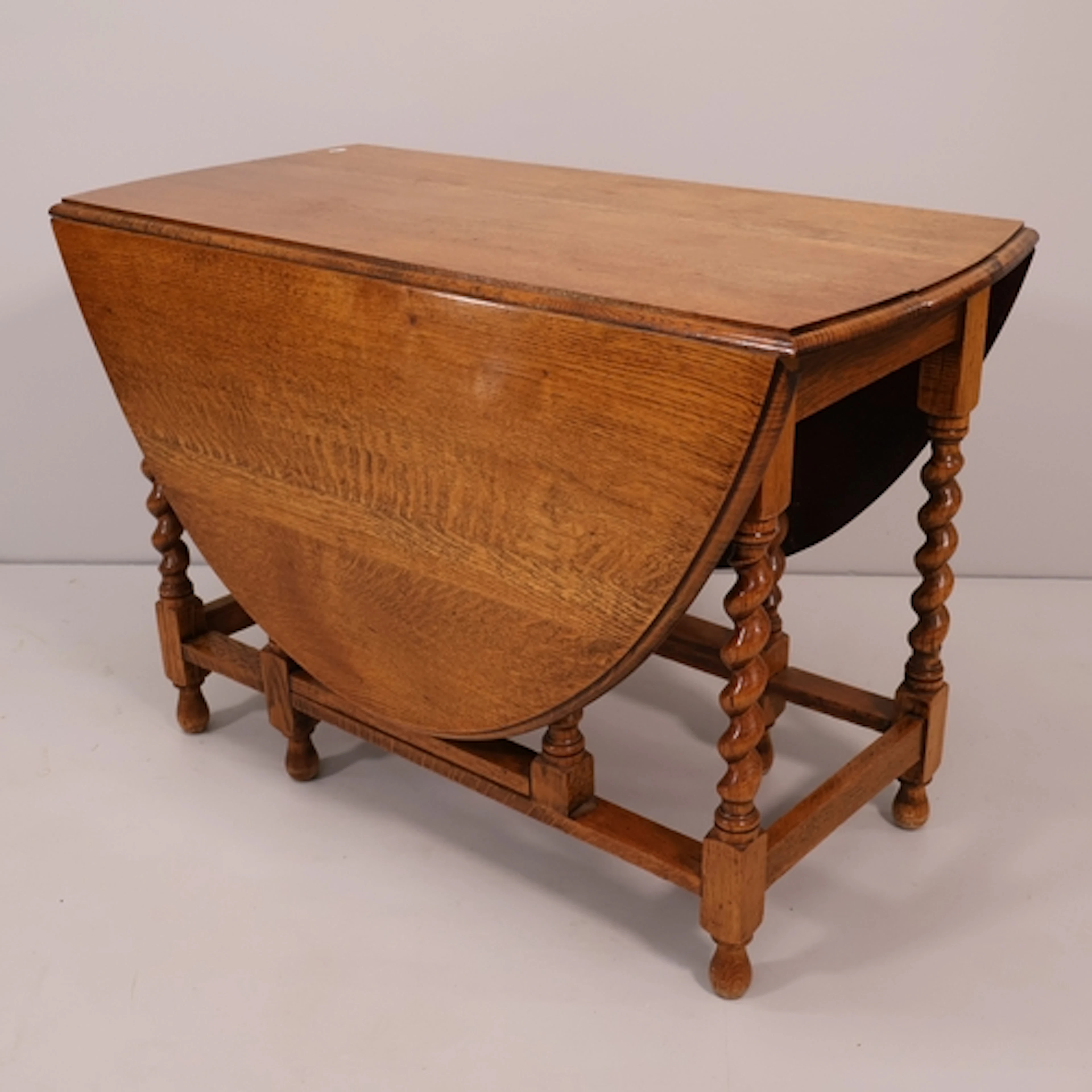 An oak oval gateleg table, with barley twist legs. W104cm, H...