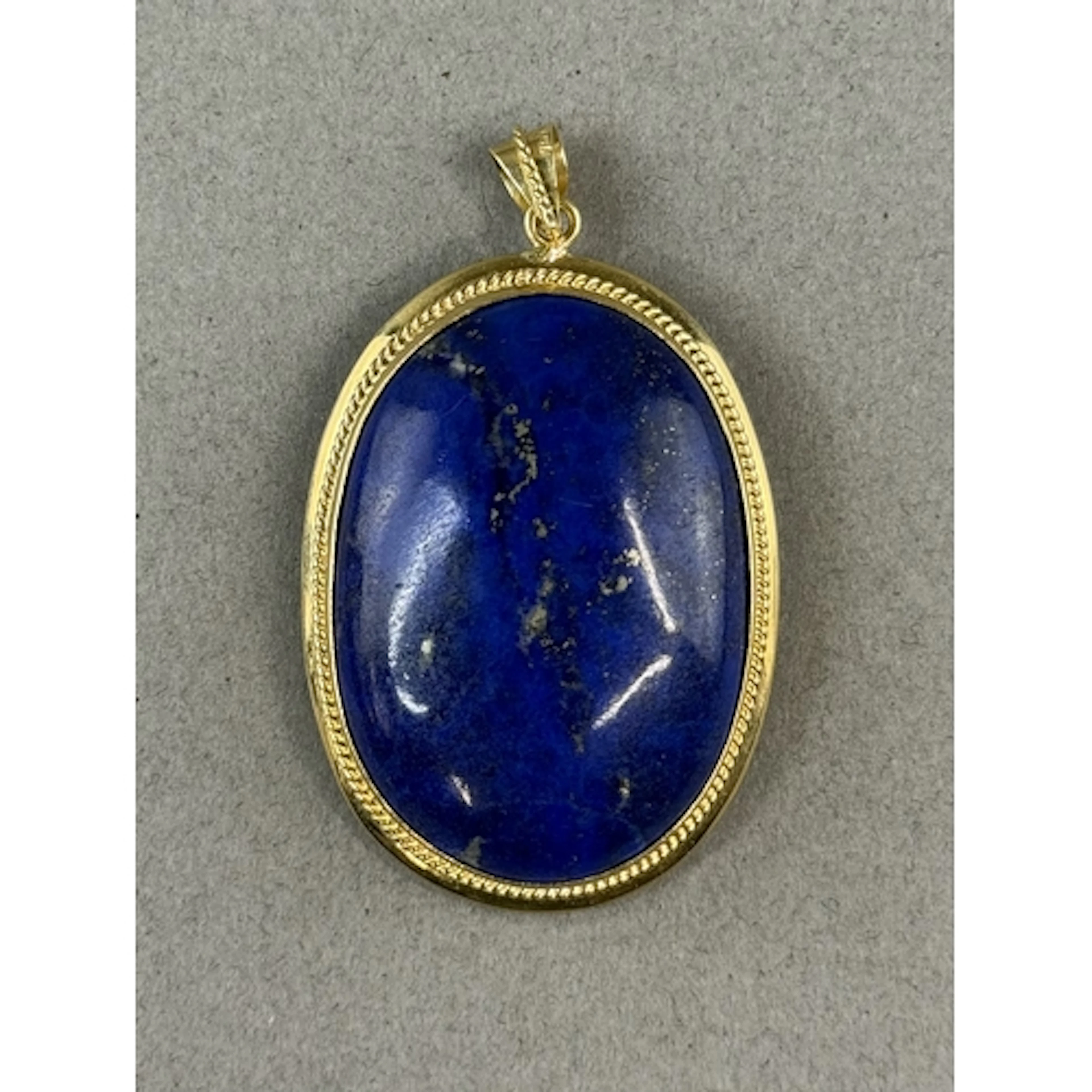Jewellery: a lapis lazuli pendant, mounted in yellow metal w...