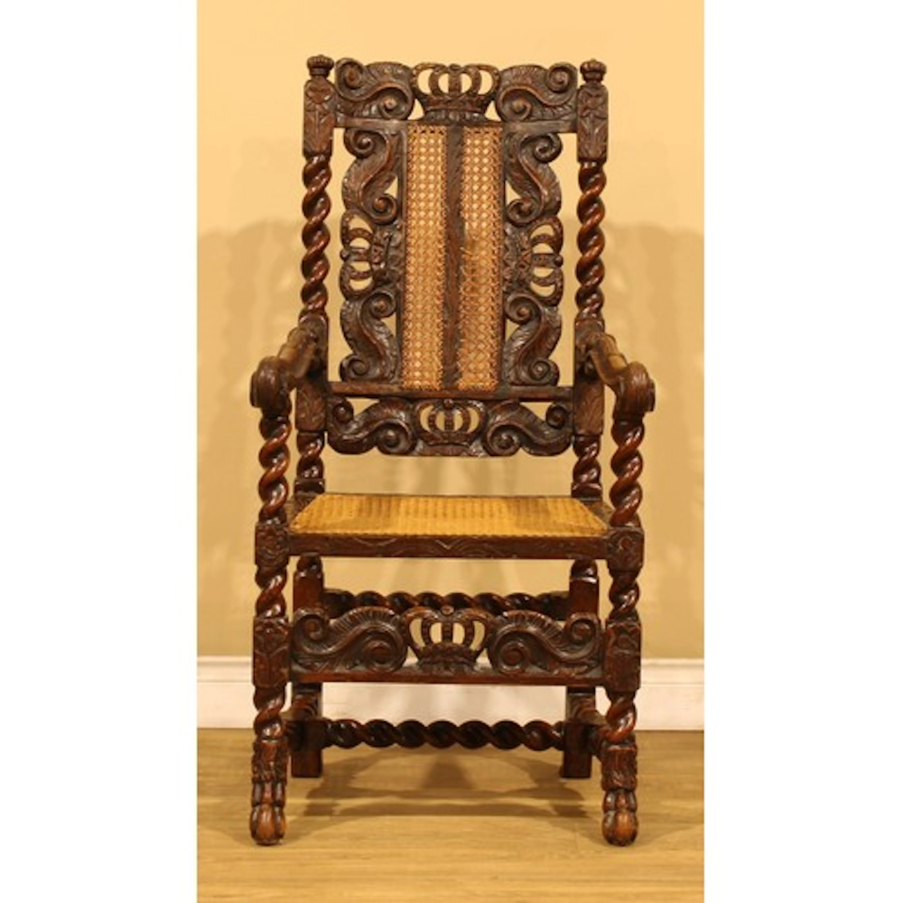 A late Victorian Carolean Revival open armchair, cane back a...