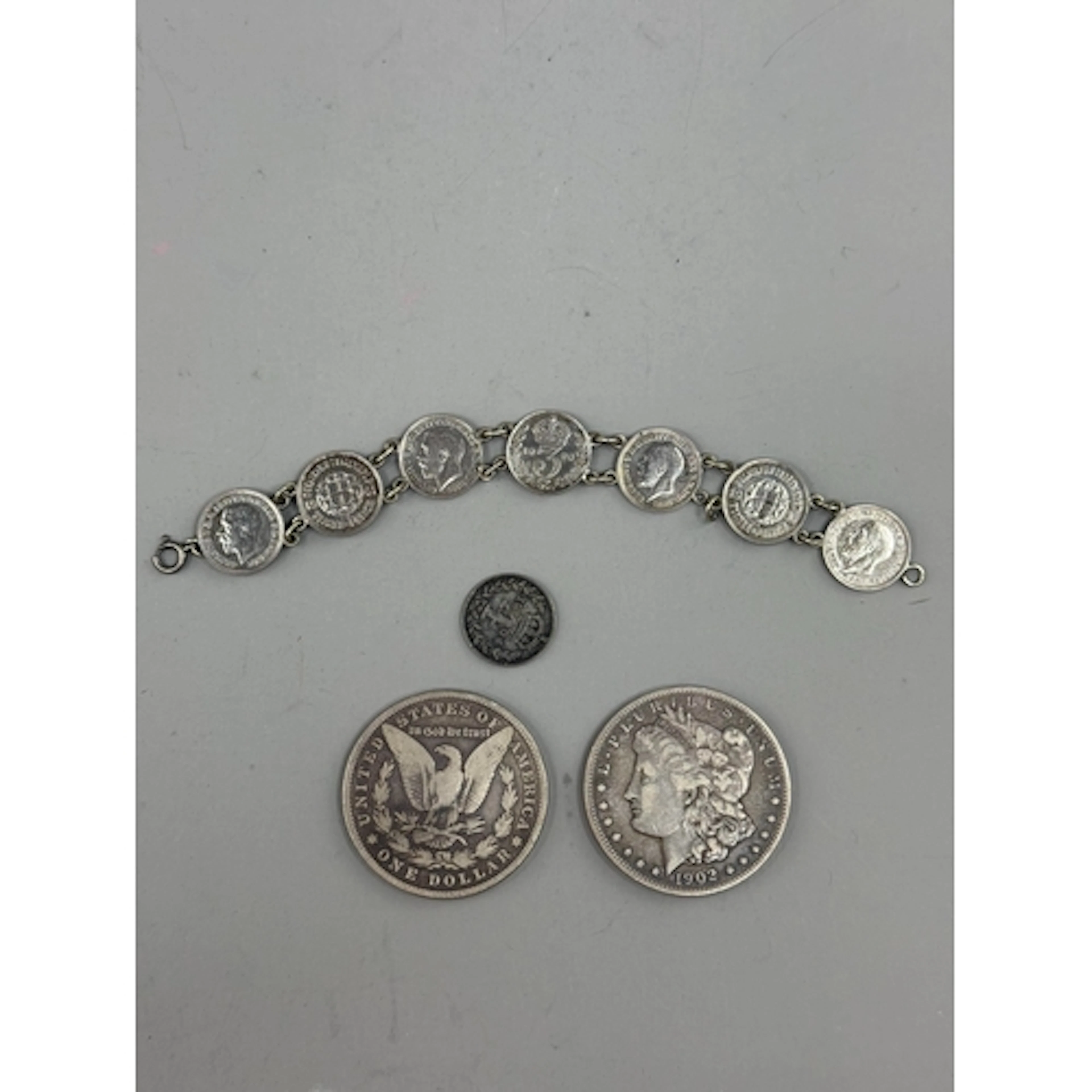Coins: a 1902 US Morgan silver dollar, Philadelphia mint, an...