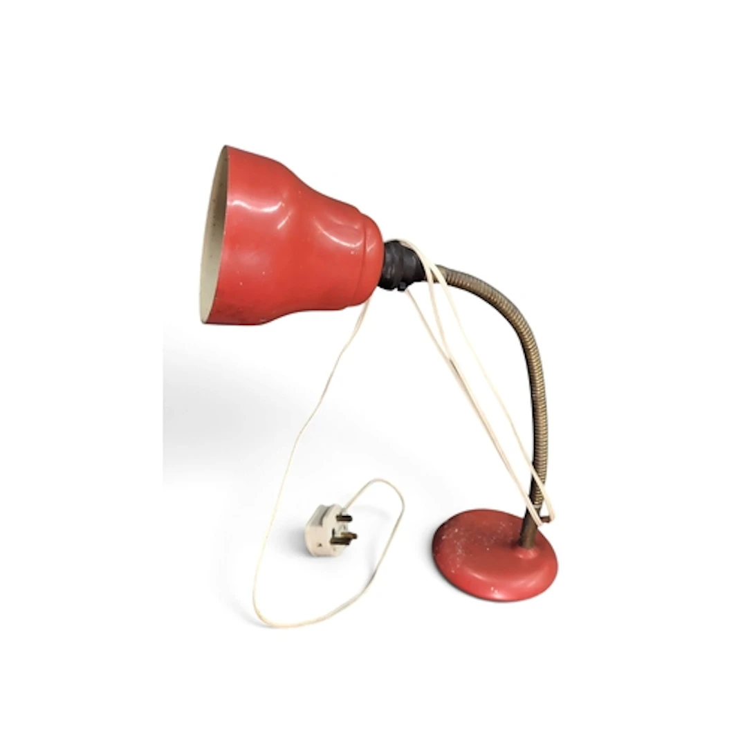 Red-painted metal desk lamp with a flared, cream-lined shade...
