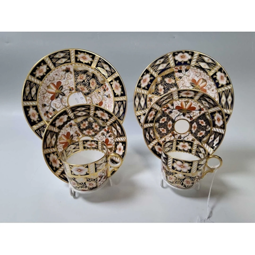 A PAIR OF ROYAL CROWN DERBY TEA TRIOS, each comprising a cup...