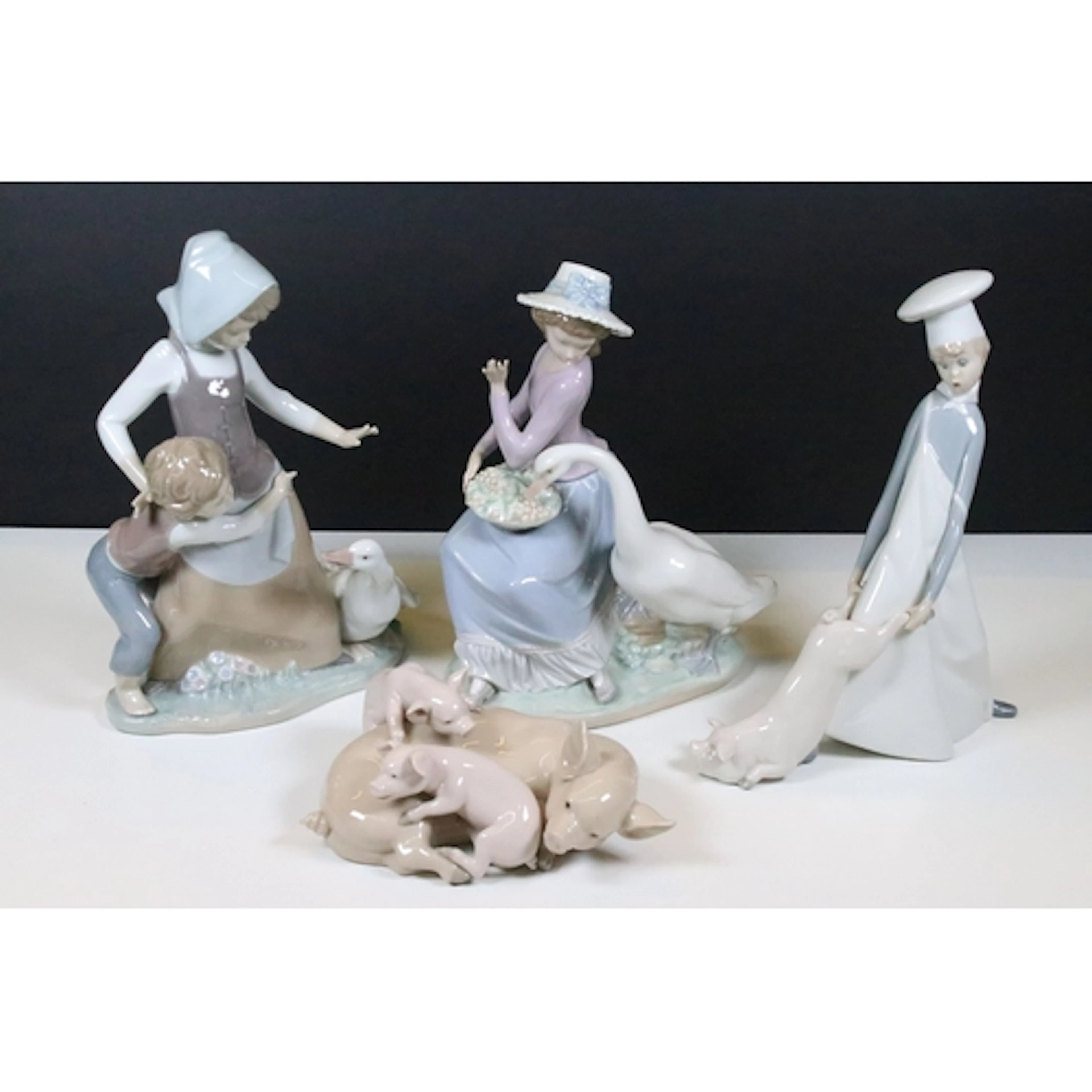 Group of four Lladro figures, to comprise 'Playful Piglets',...