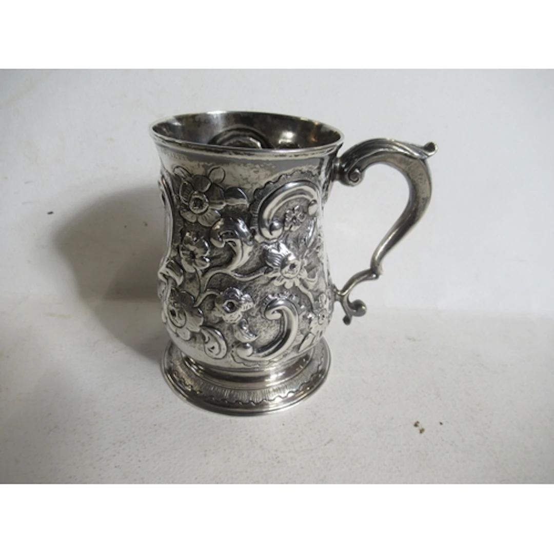 A Georgian silver tankard, with embossed floral decoration a...