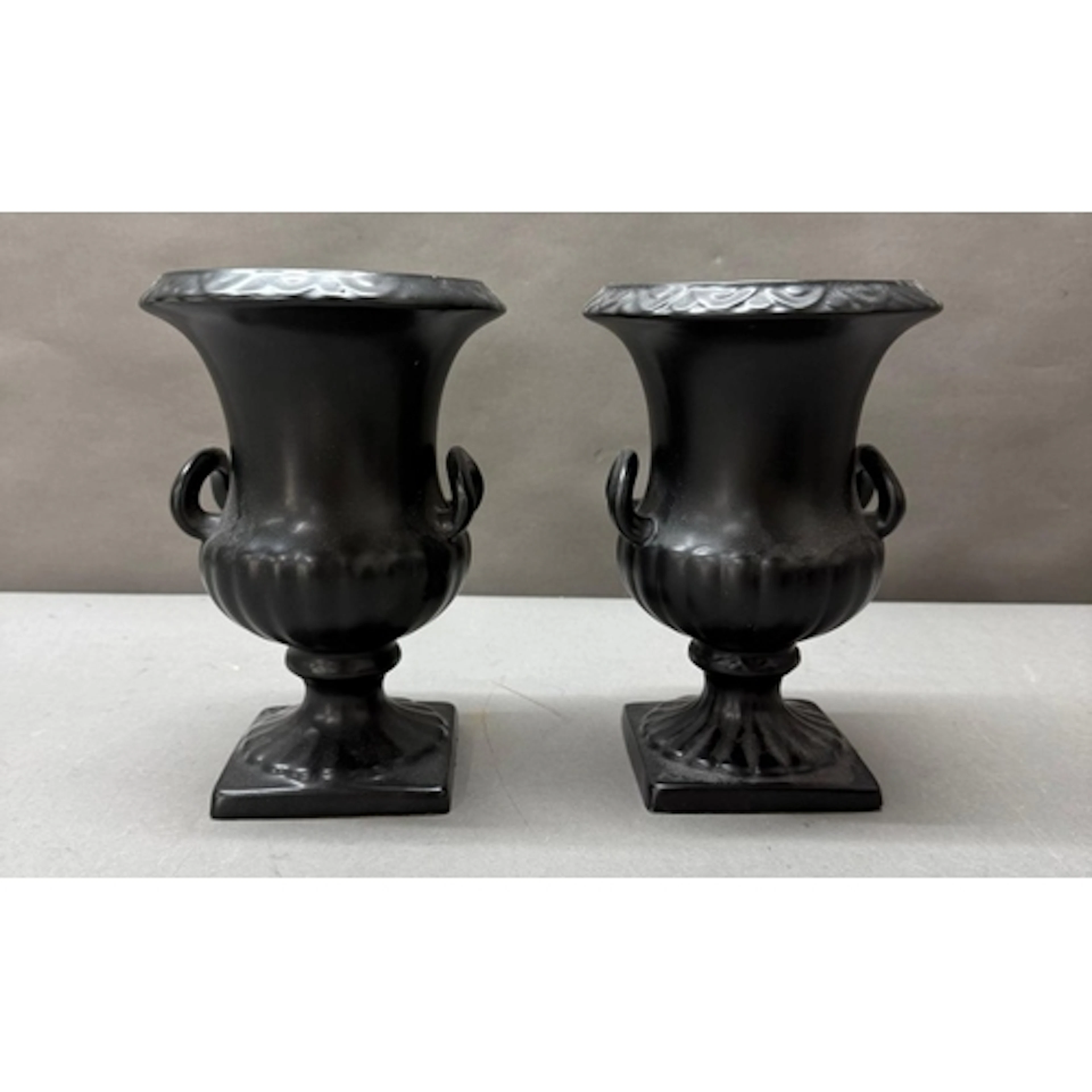 A pair of black ceramic urn vases