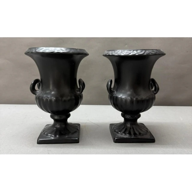 A pair of black ceramic urn vases
