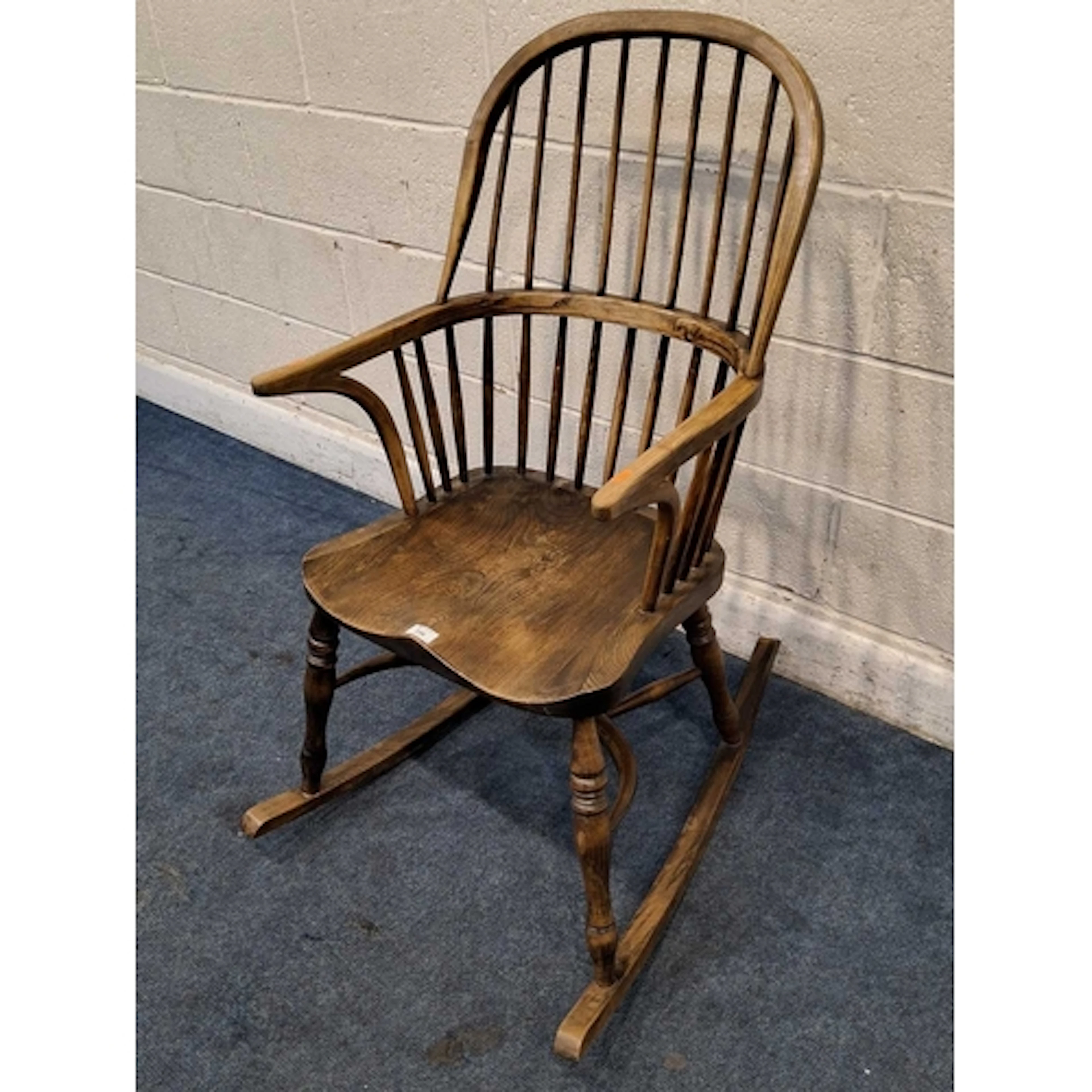 AN ELM WINDSOR ROCKING CHAIR, with a bentwood armrests, a di...
