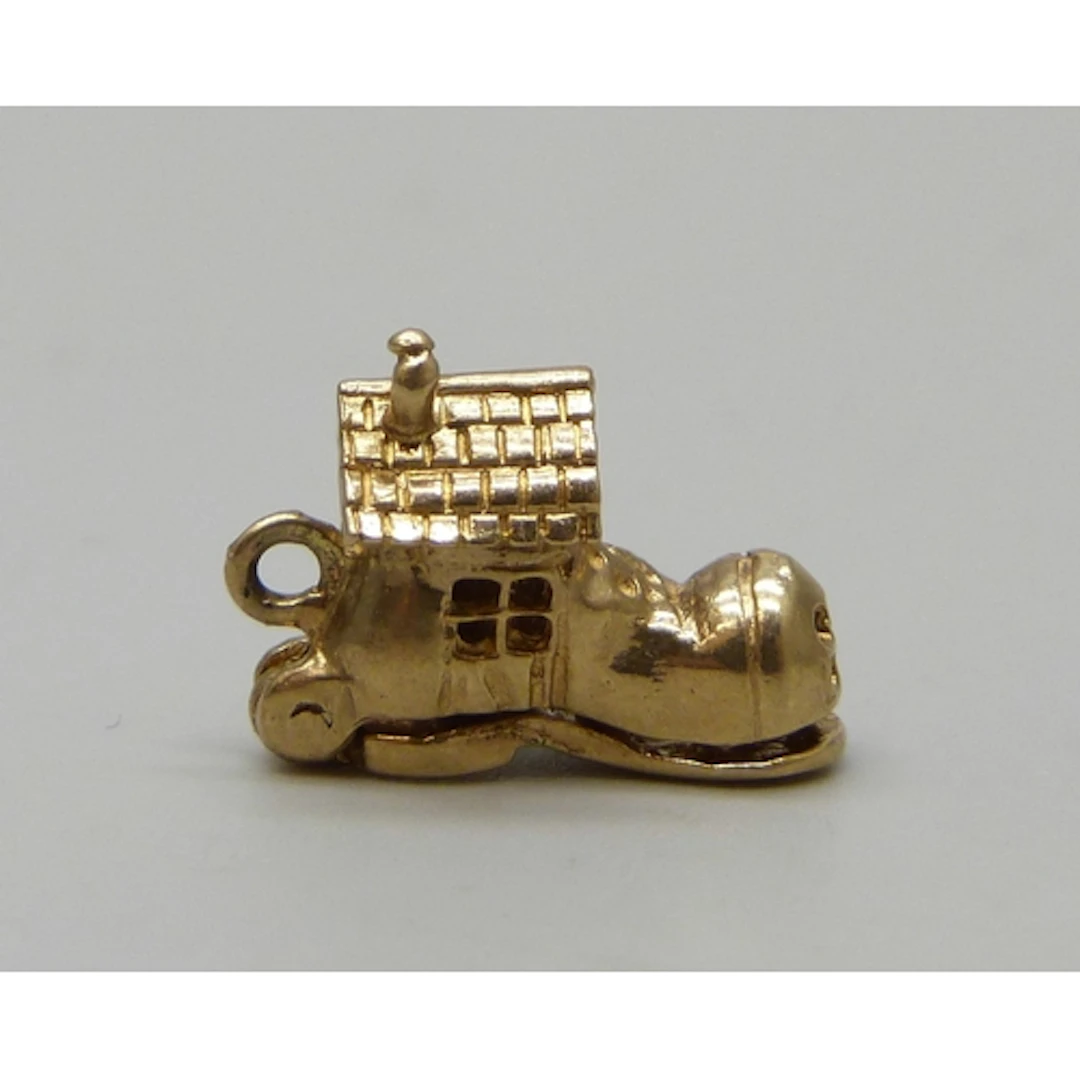 A yellow metal charm in the form of The Old Woman Who Lived ...