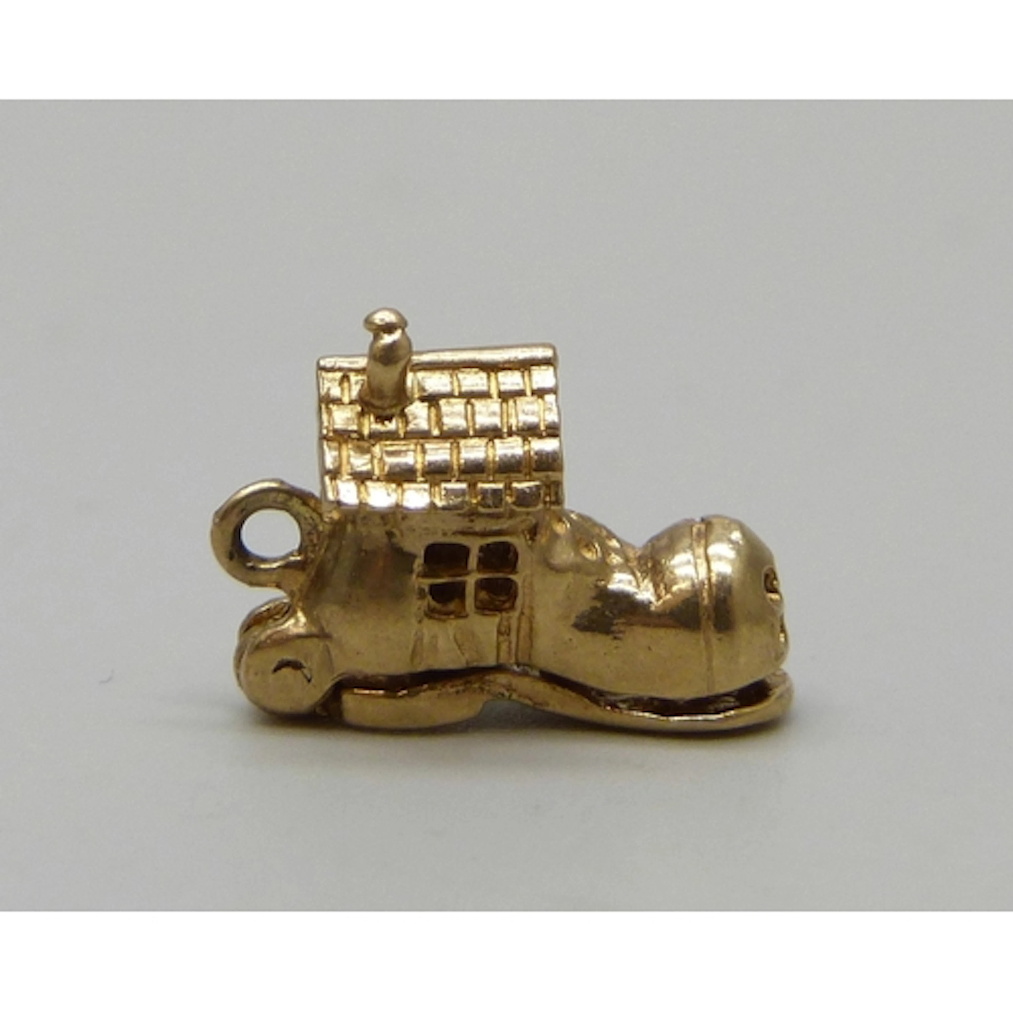 A yellow metal charm in the form of The Old Woman Who Lived ...