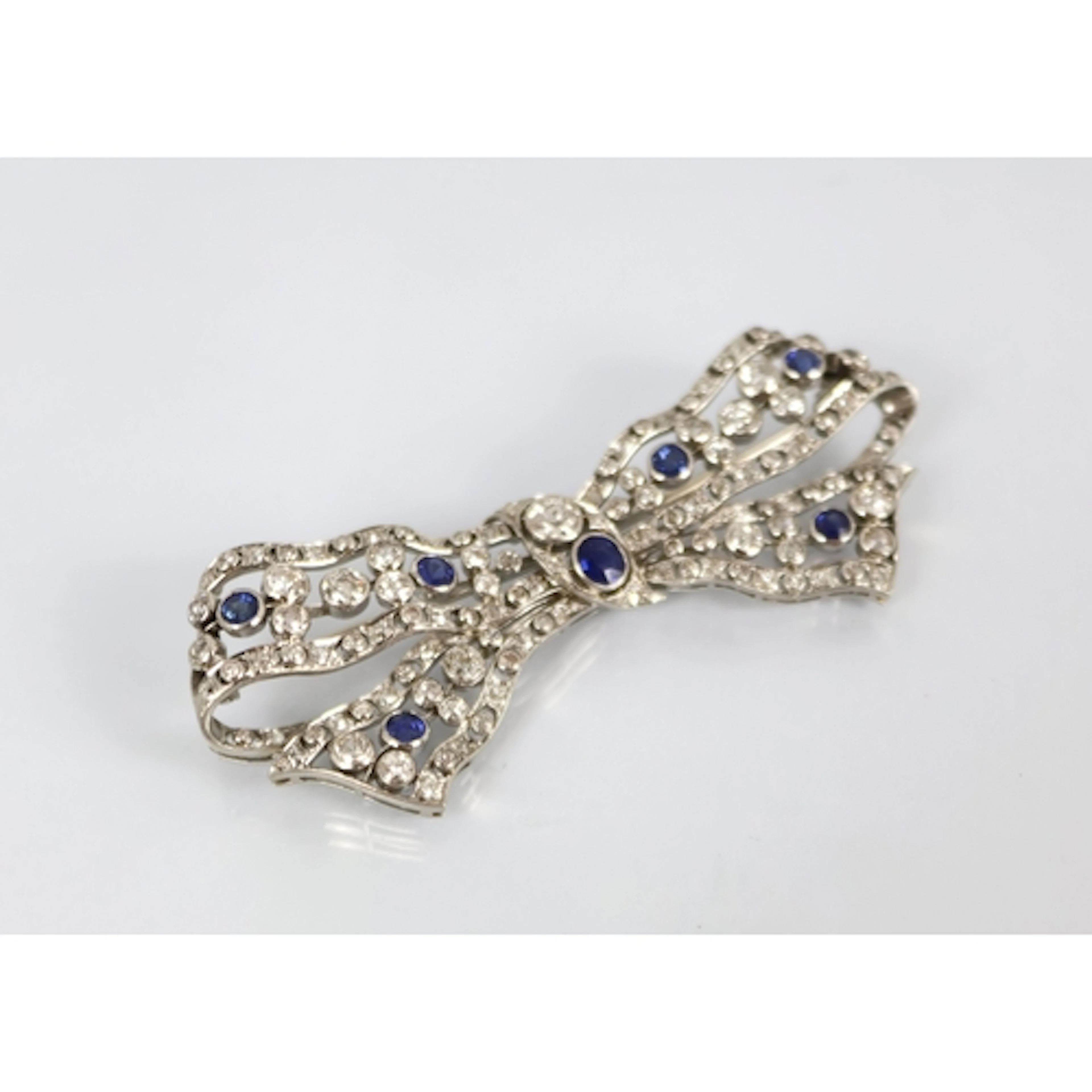 A Belle Epoque diamond and sapphire set bow brooch, the ribb...