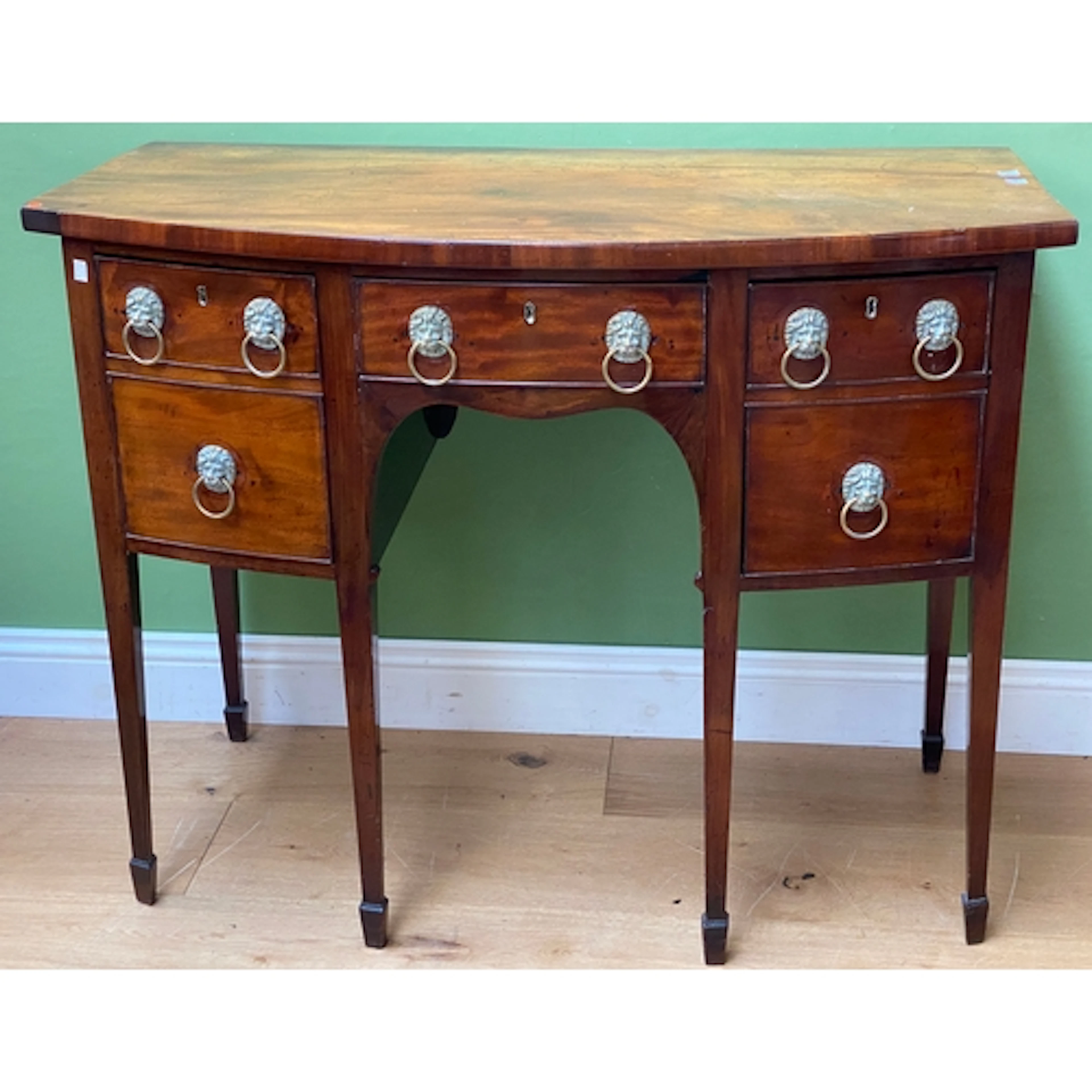 A George III mahogany bowfront sideboard raised on six squar...