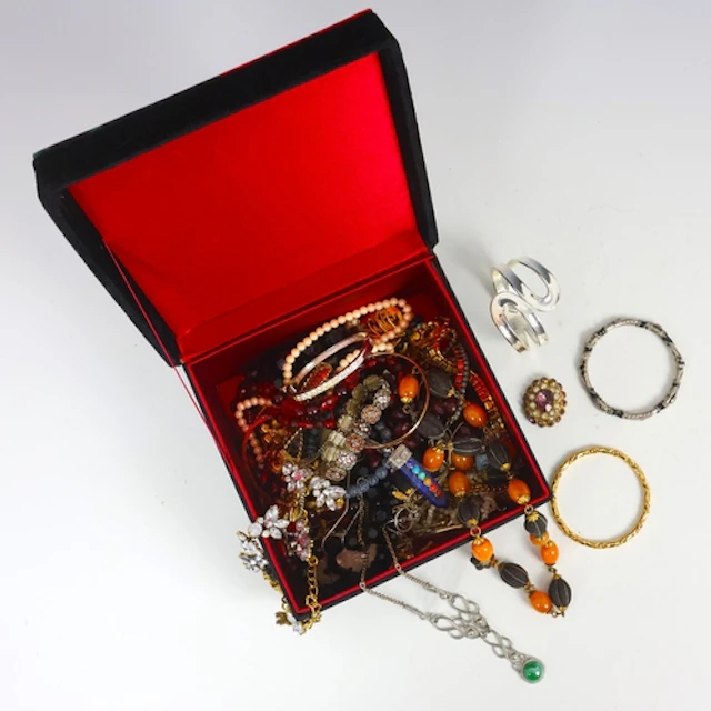 A selection of costume jewellery, including a strand of 'amb...