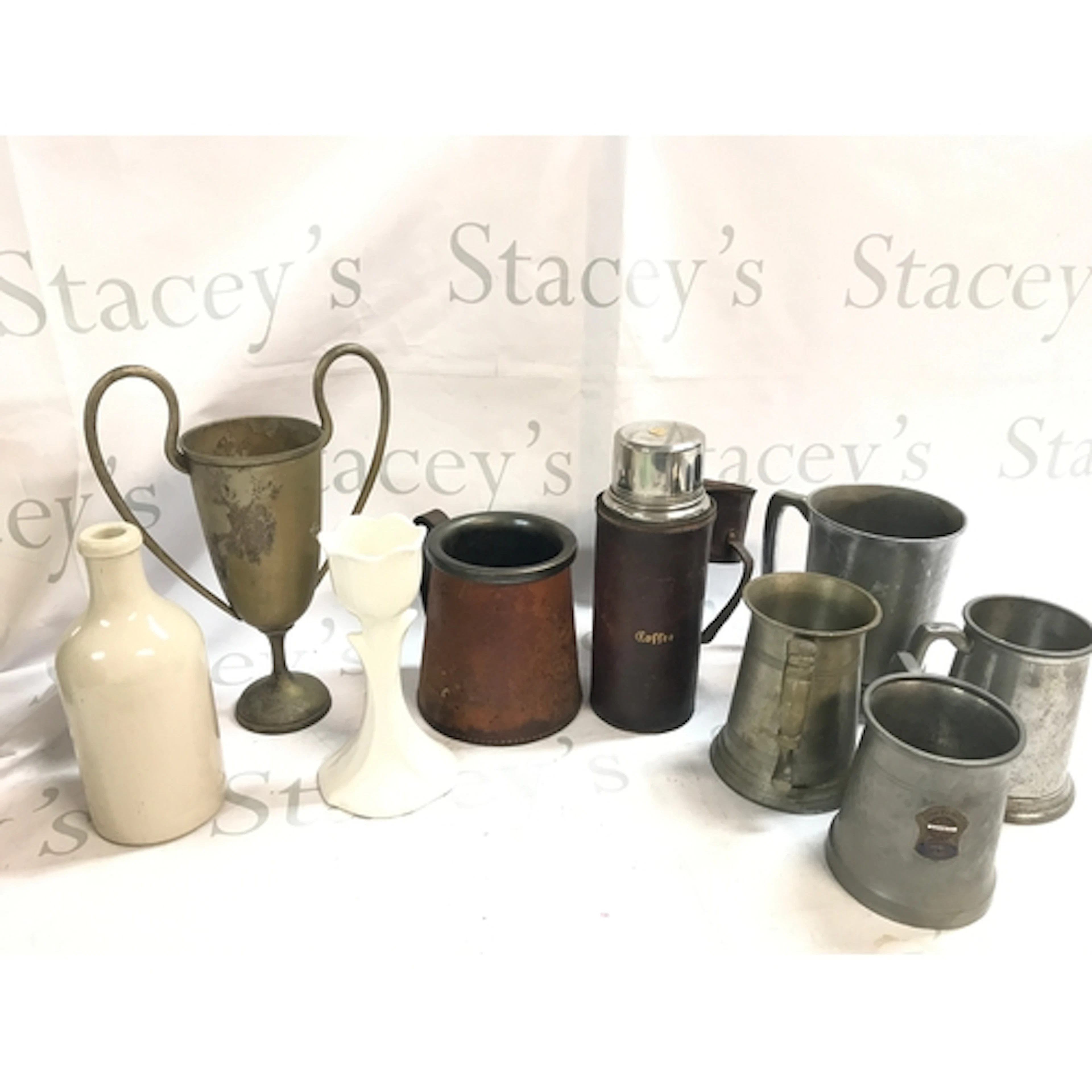a collection of pewter teapots including a ceramic example, ...
