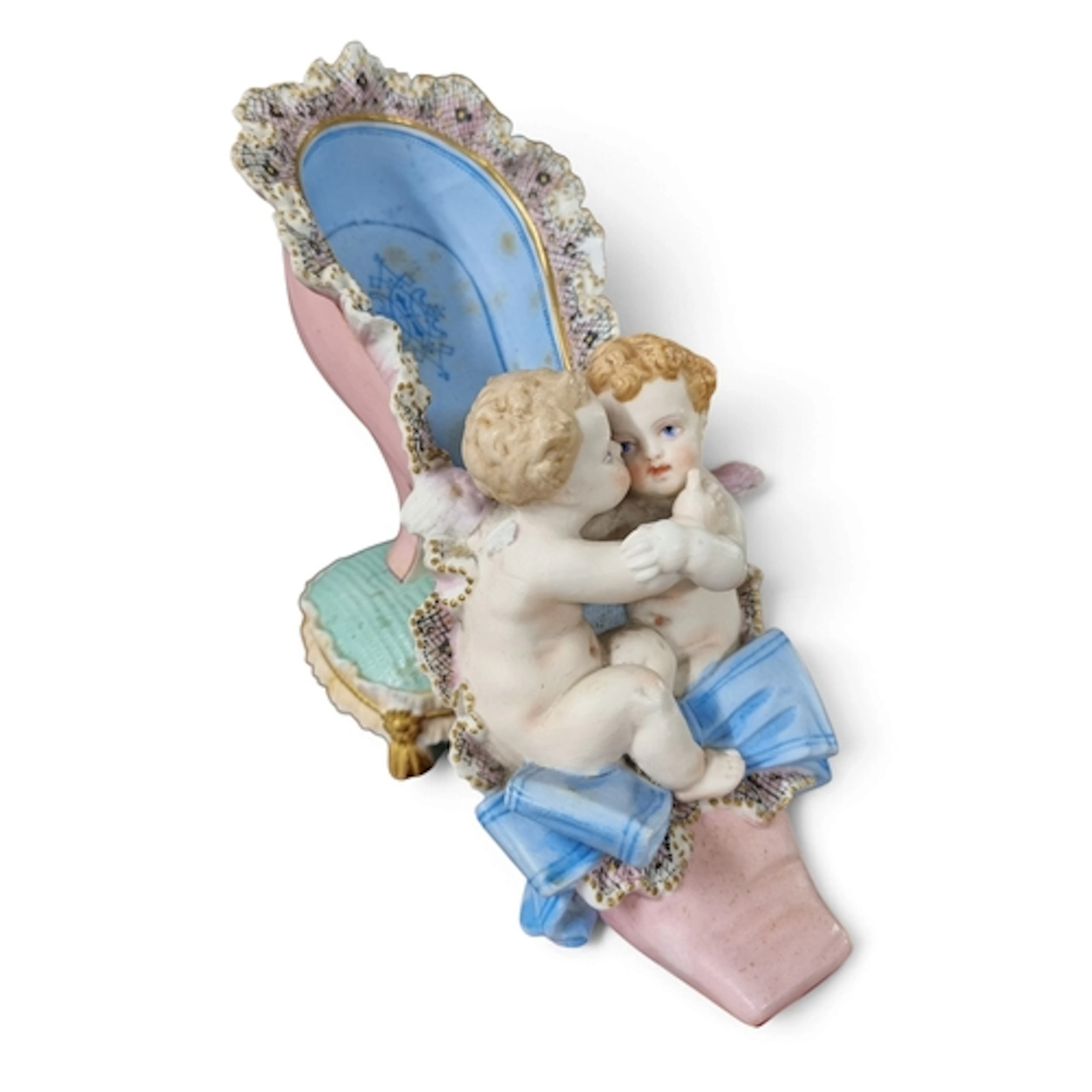 A French Porcelain piece depicting Cherubs sitting in a shoe...
