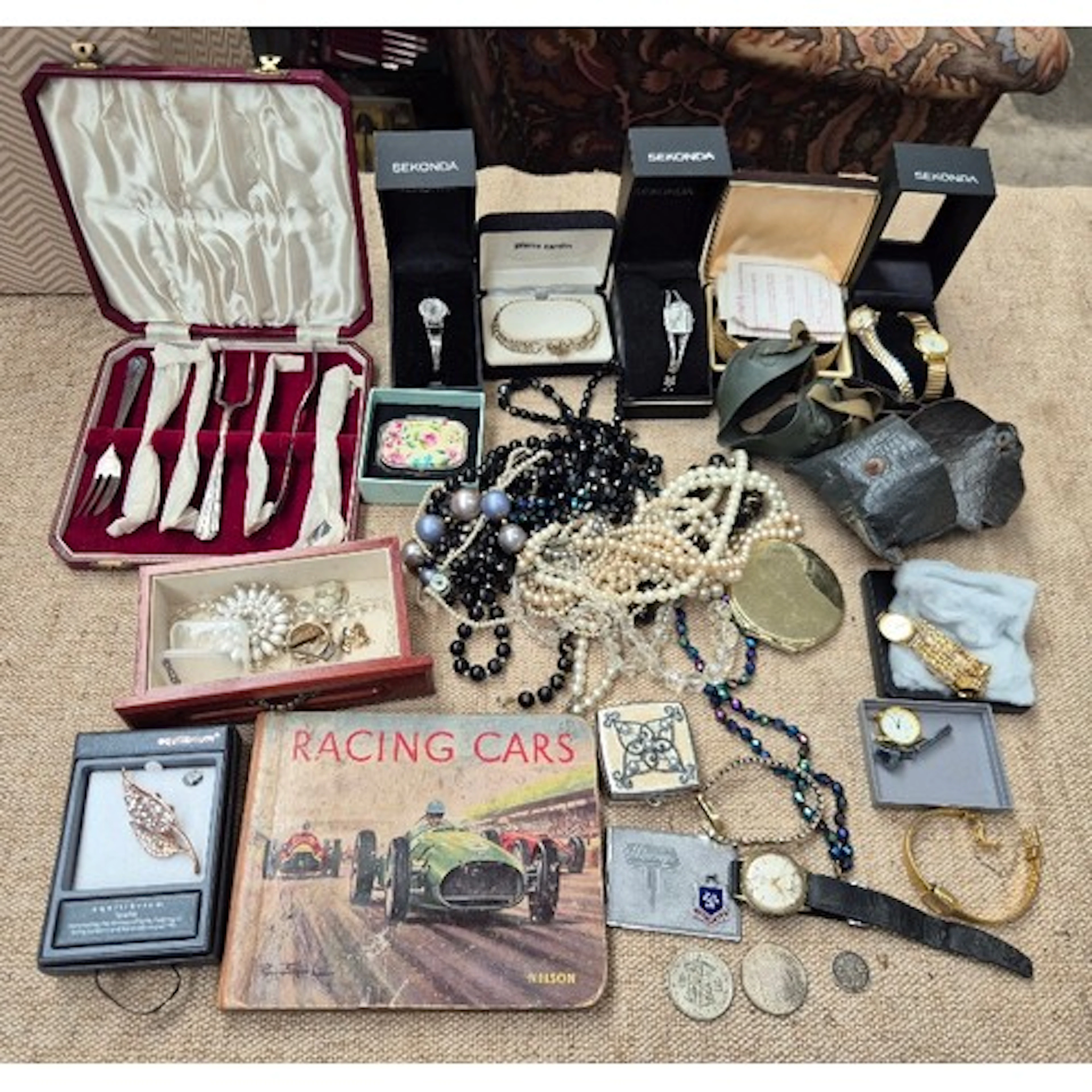 A box of costume jewellery, watches, cutlery, a vintage raci...