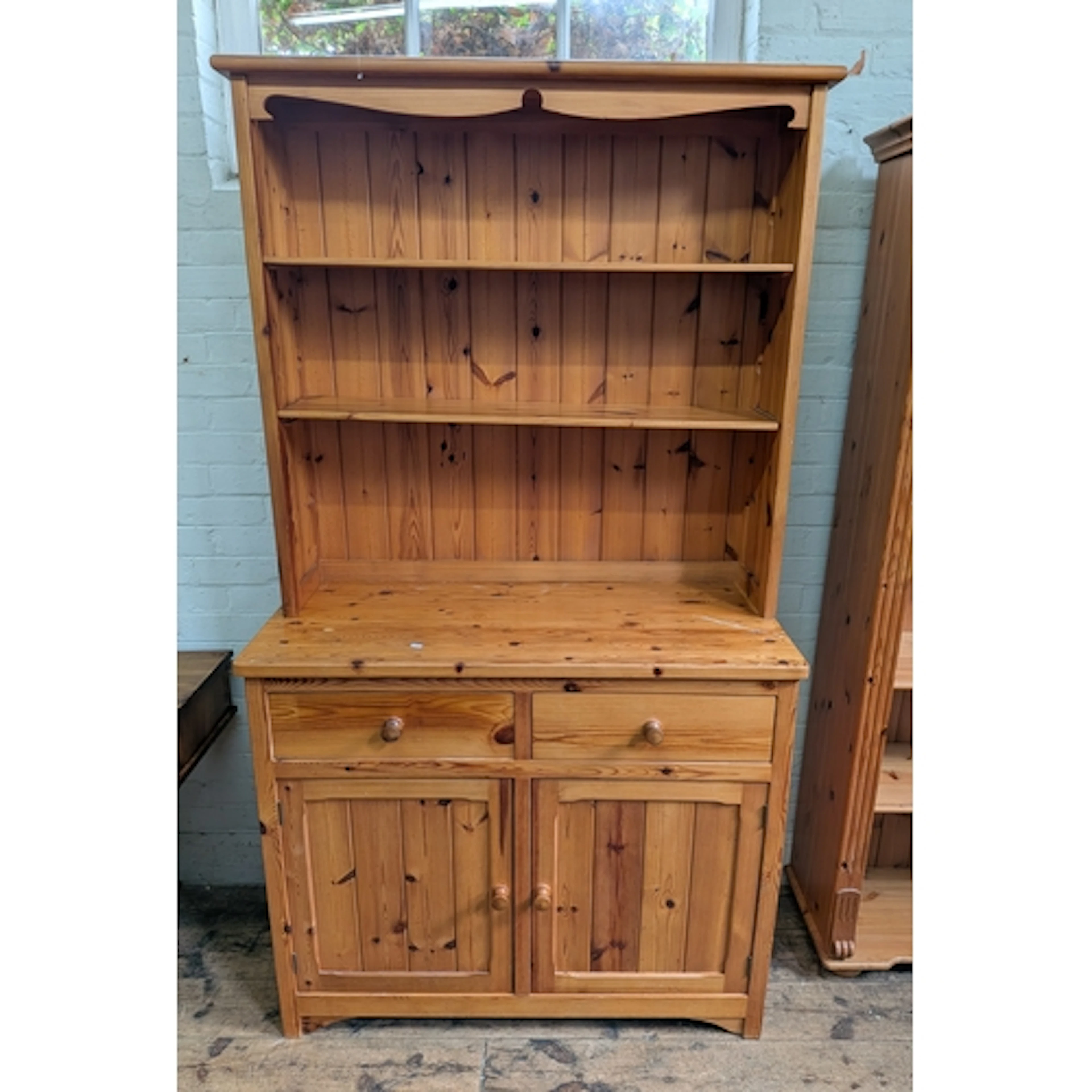 A modern pine kitchen dresser with shelf back, cupboards and...