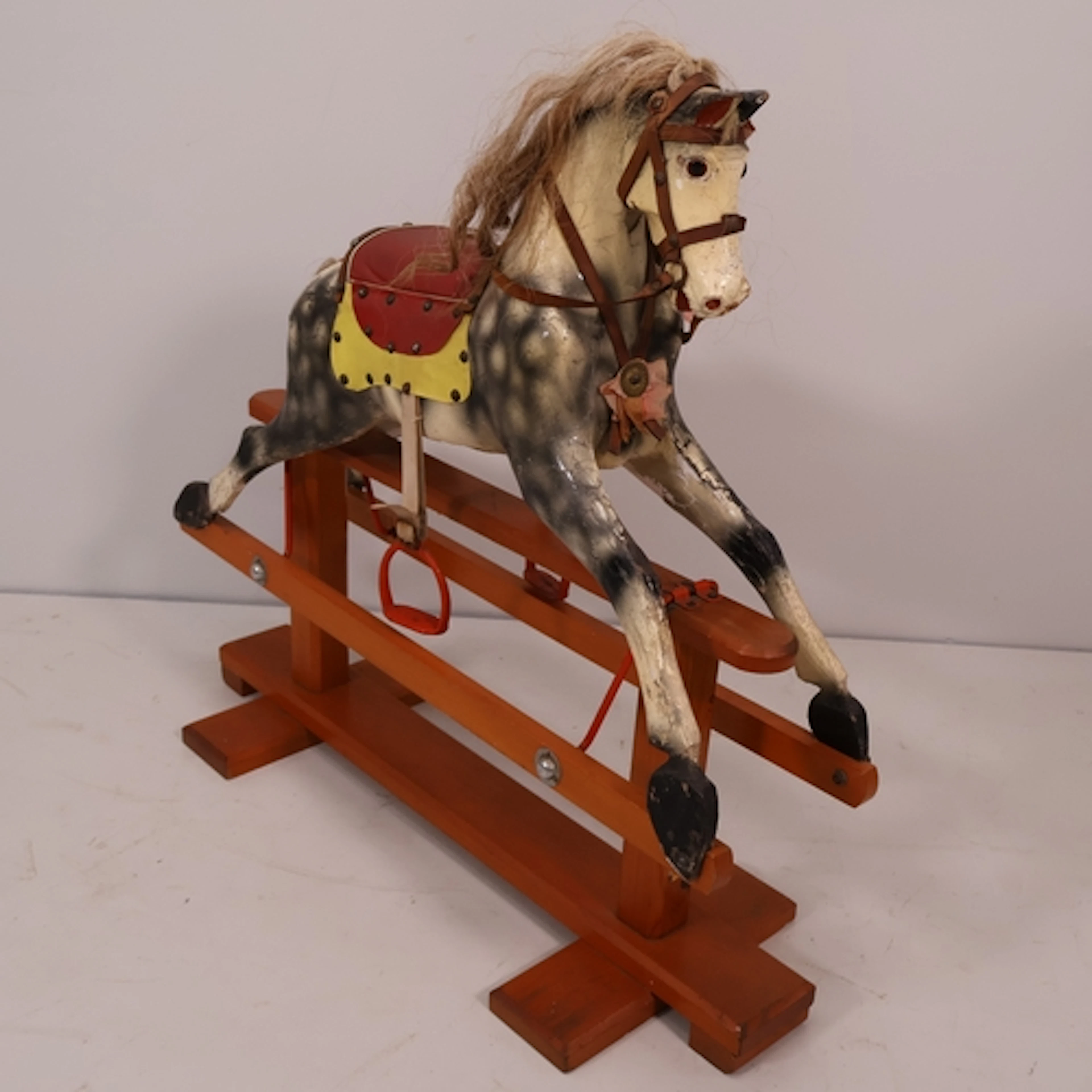 An antique small sized dappled grey wooden rocking horse, gl...