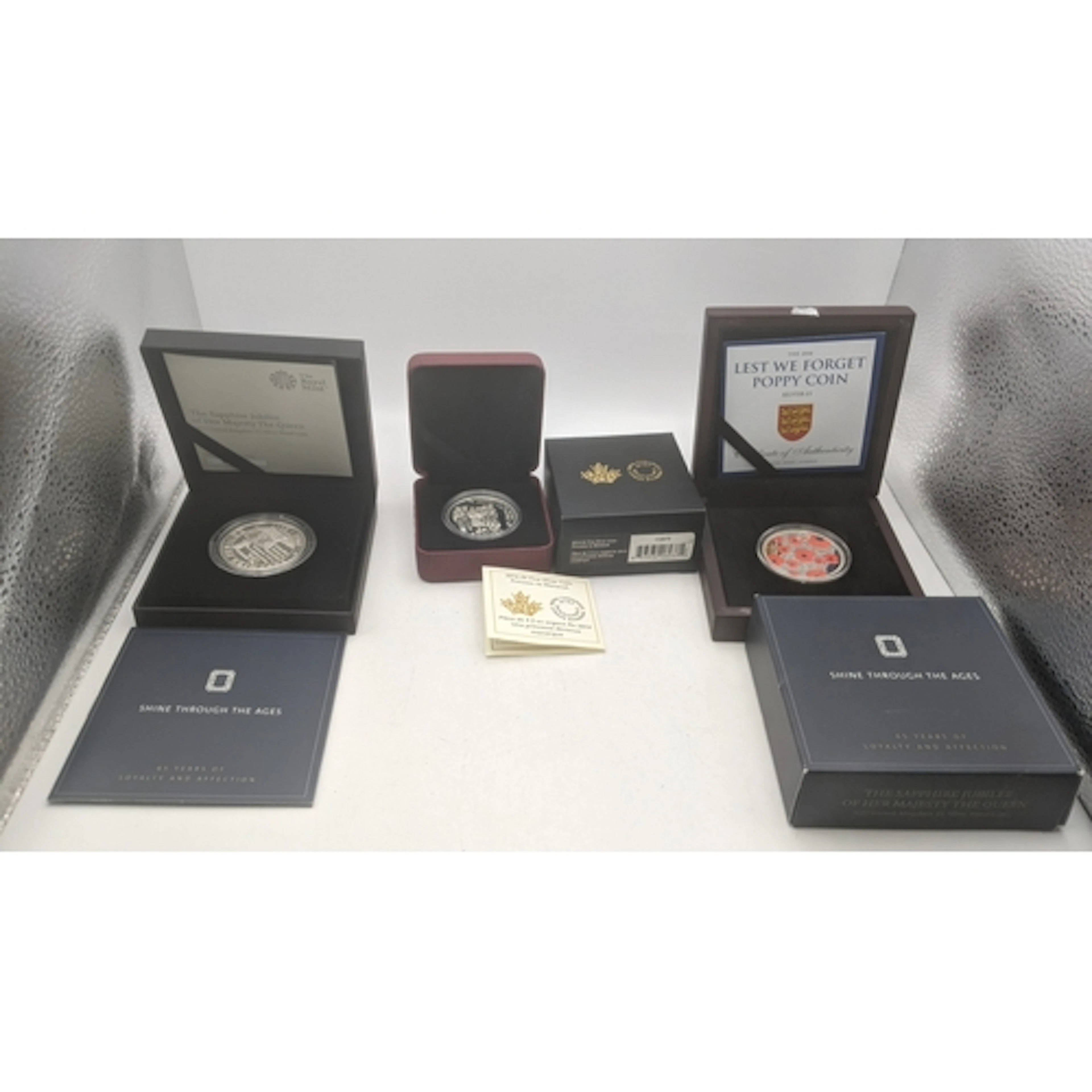 Three boxed commemorative silver coins to include a Sapphire...