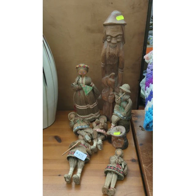 A group of straw-fibre dolls with wooden heads and ribbon-tr...