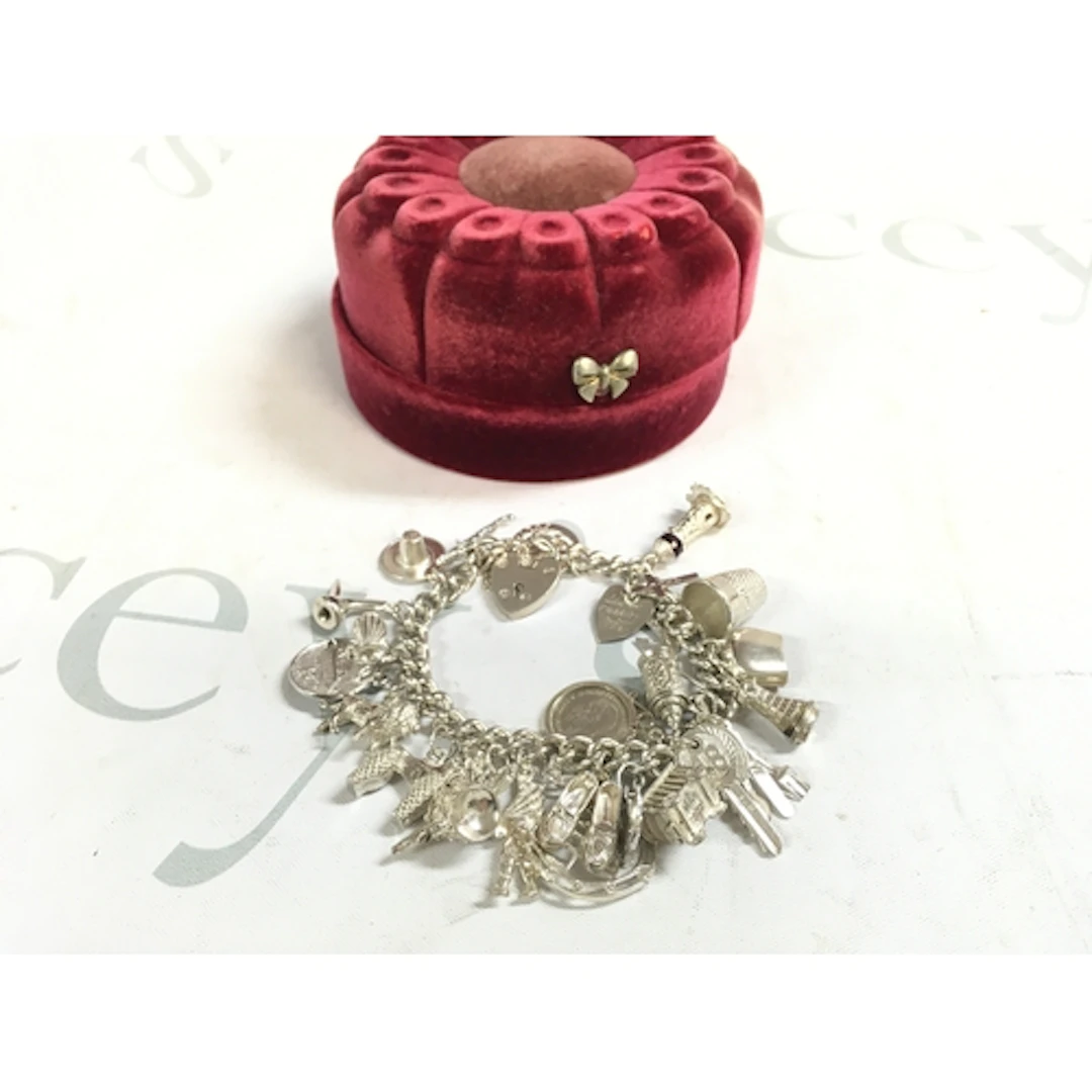 A silver charm bracelet (60s/70s/80s) 75grams. Approx 22 cha...