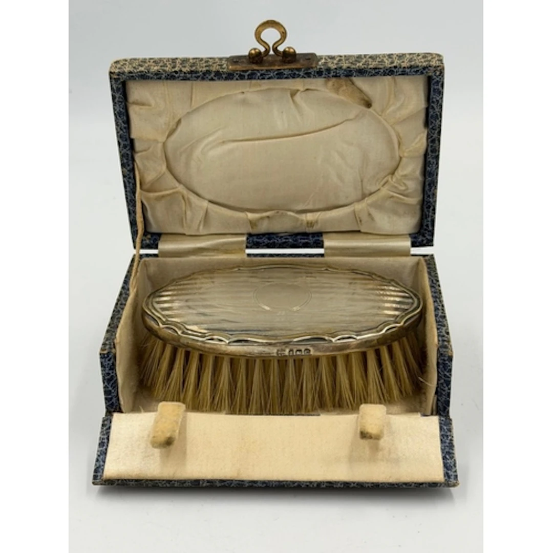 A hallmarked silver travel silver backed brush in original b...
