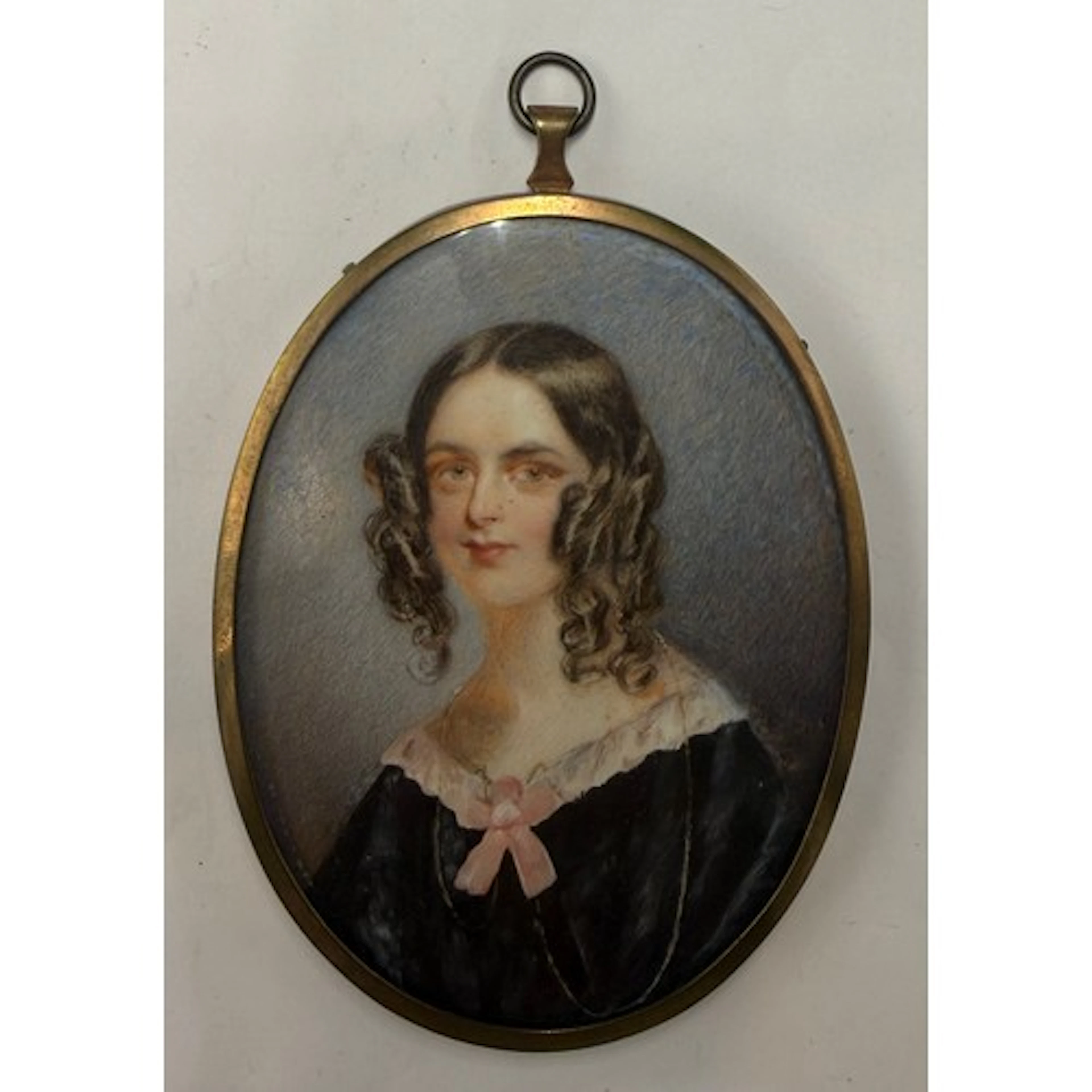 An oval portrait miniature on ivory depicting a young lady w...