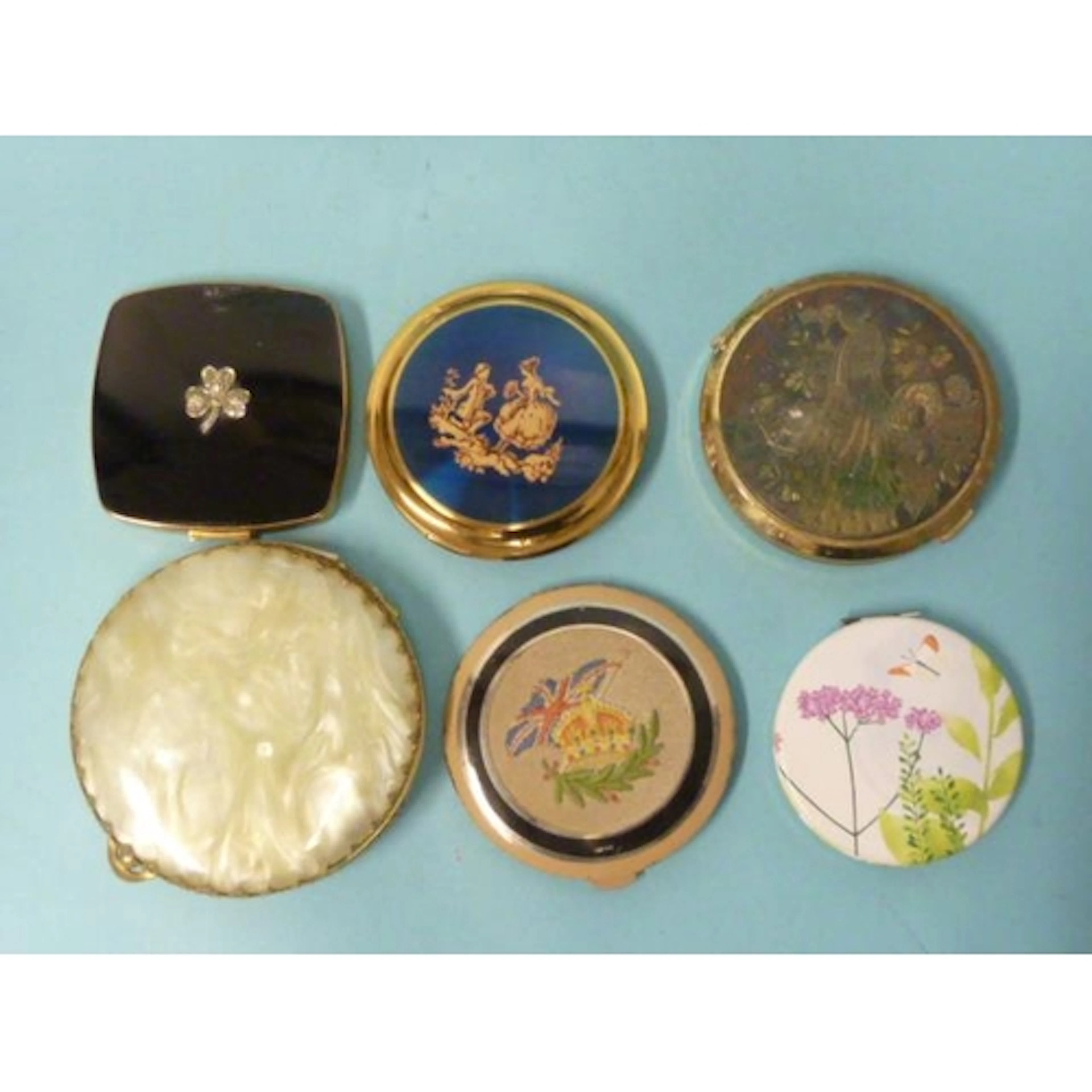 A Melissa compact with marcasite-set clover leaf on black en...