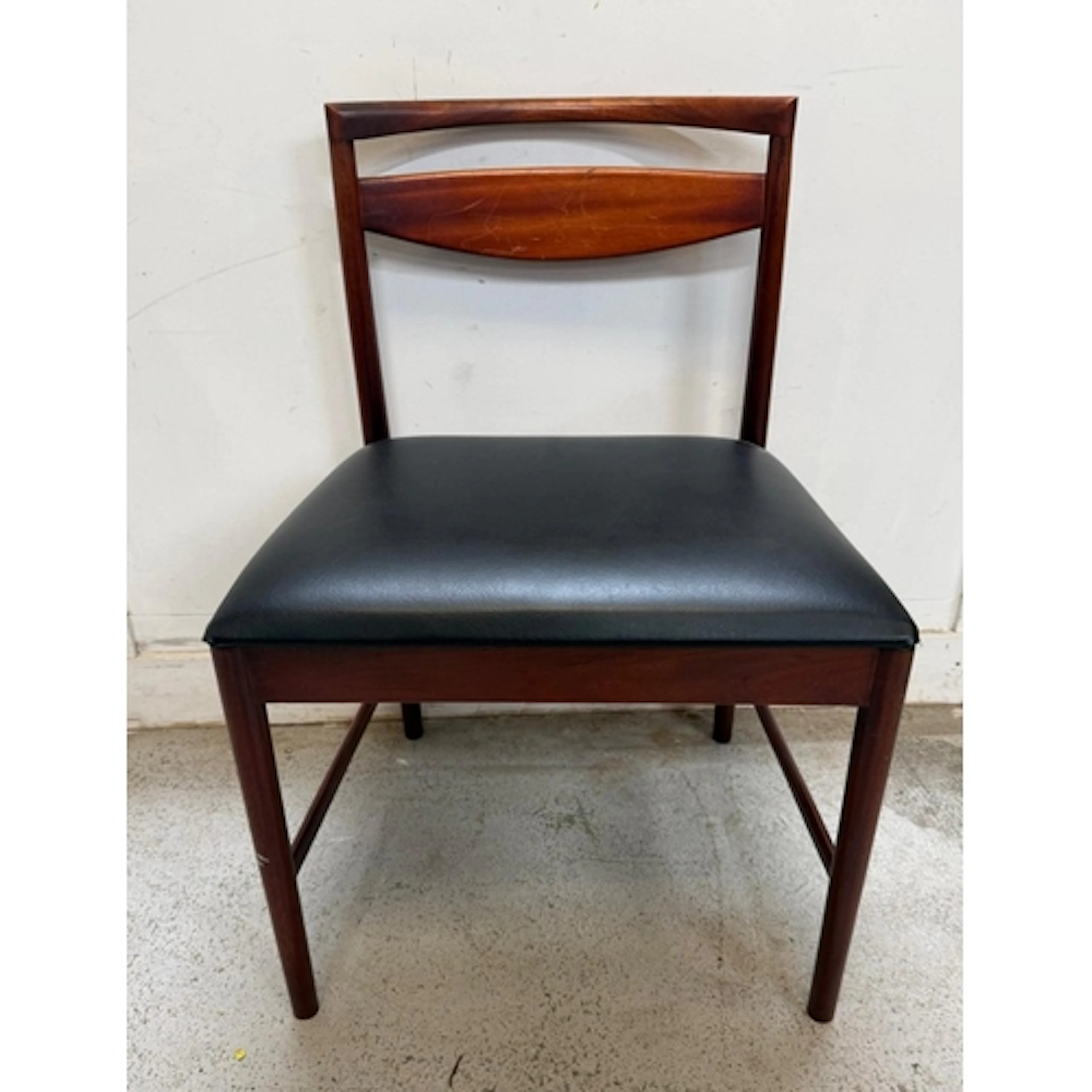A Mcintosh dining chair with black leather seat.