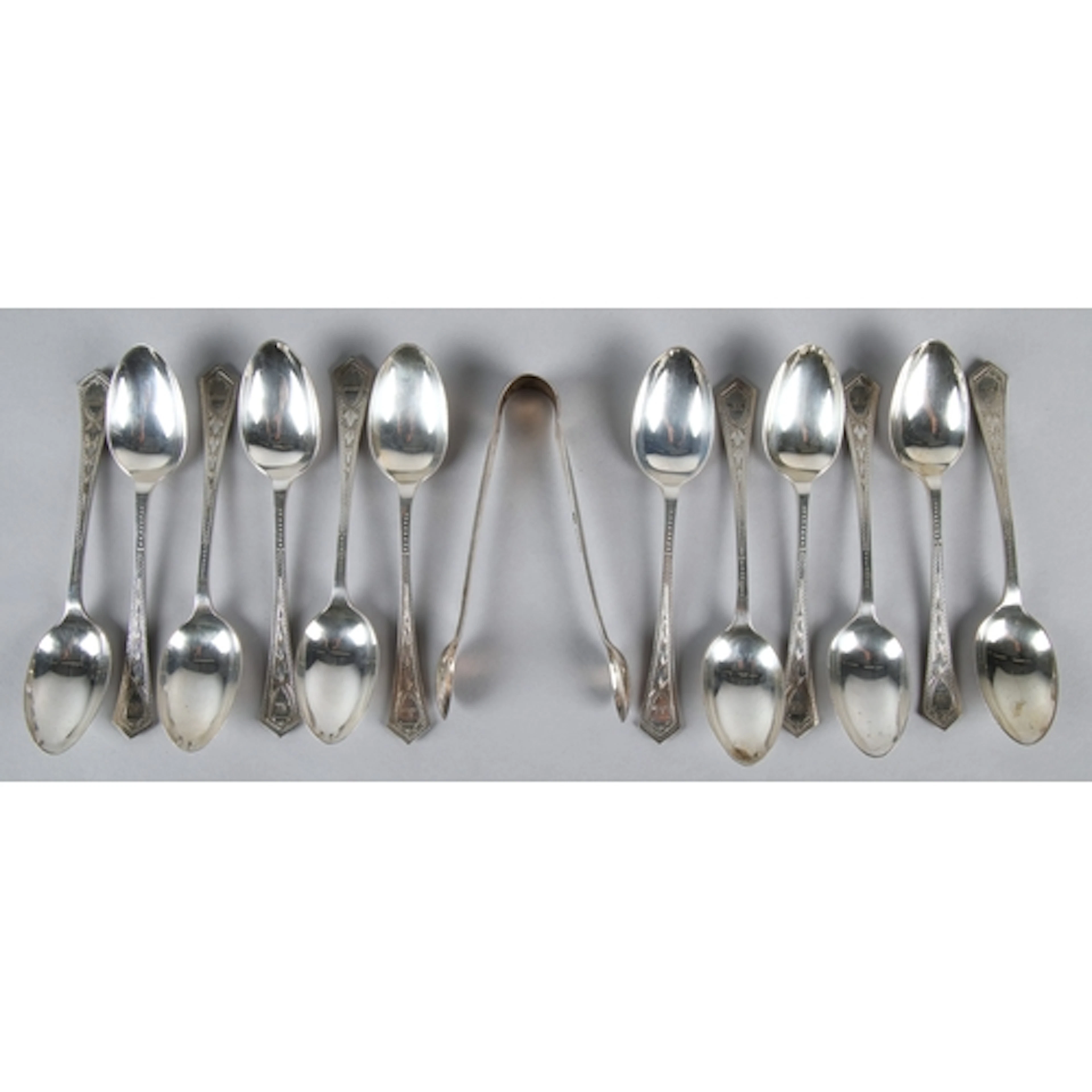 Set of silver twelve tea spoons and sugar tongs, cased, gros...