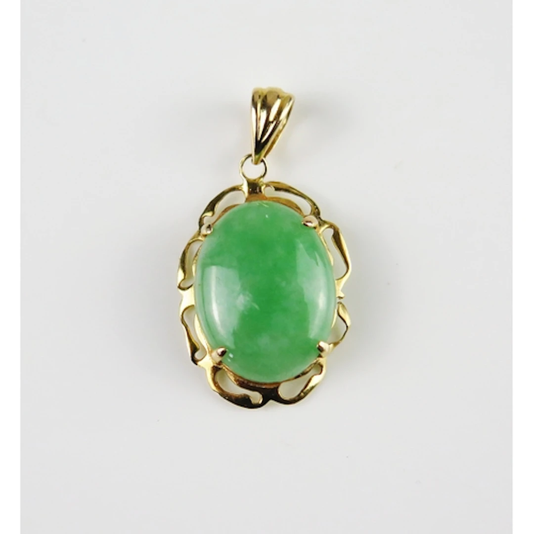 A jade pendant in a 14K yellow gold setting, 28.5mm drop, st...