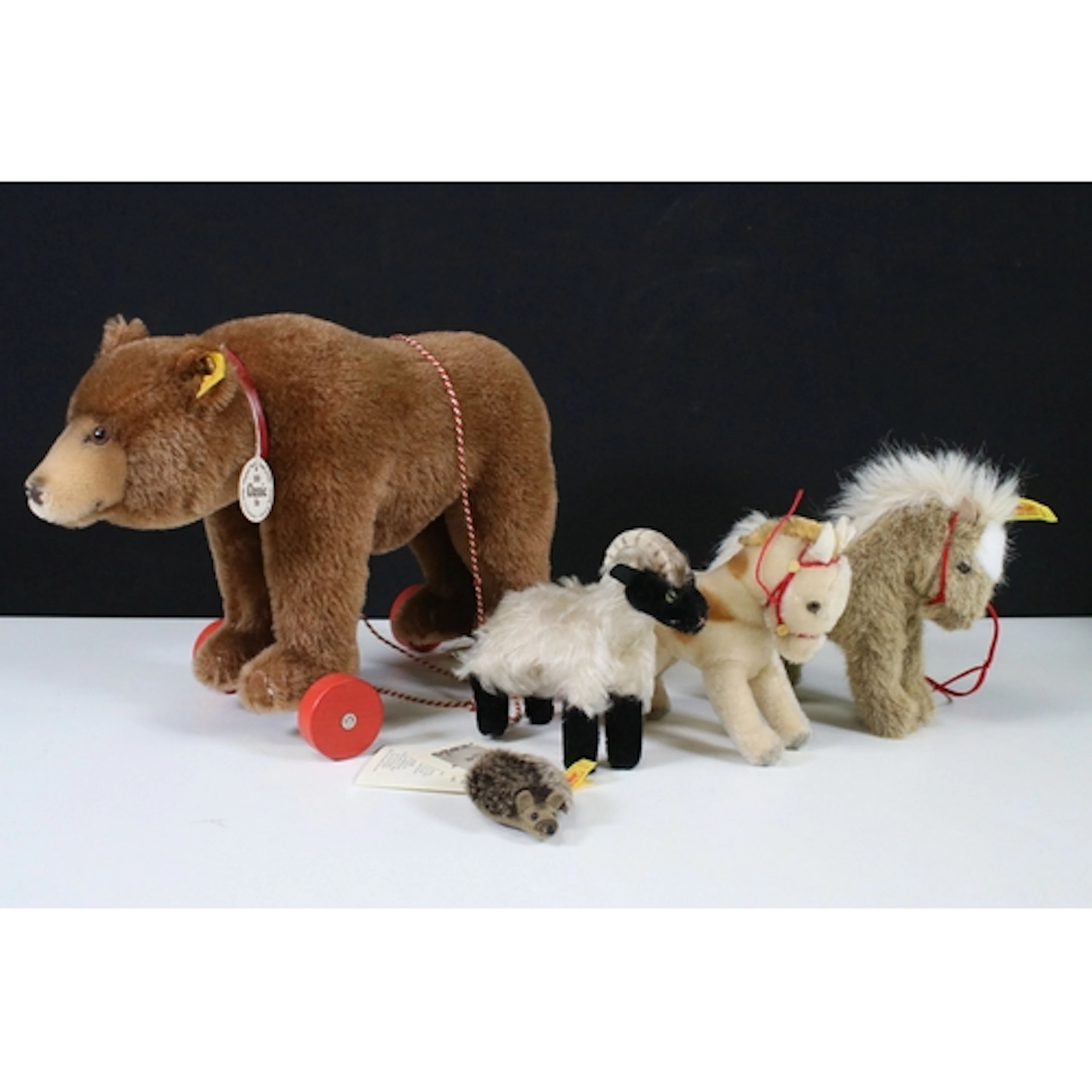 Five Steiff soft toys to include 1938 Classic Bear on wheels...