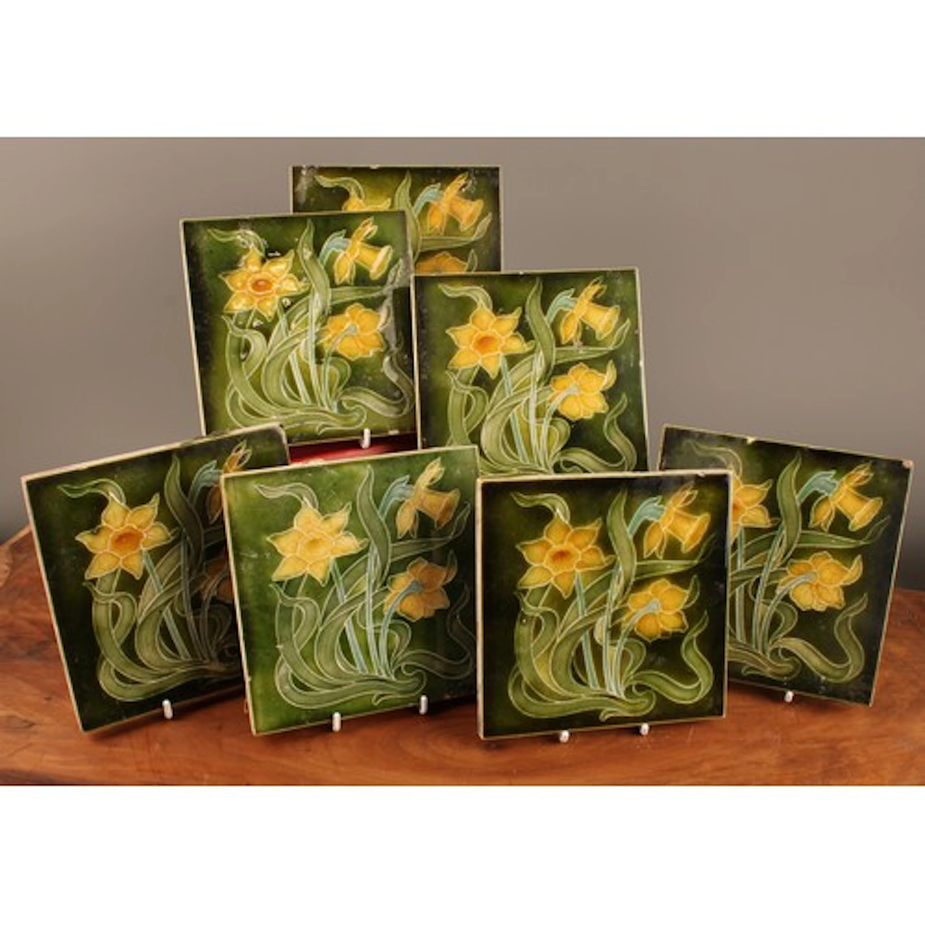 A set of seven Edwardian majolica tiles, each decorated with...