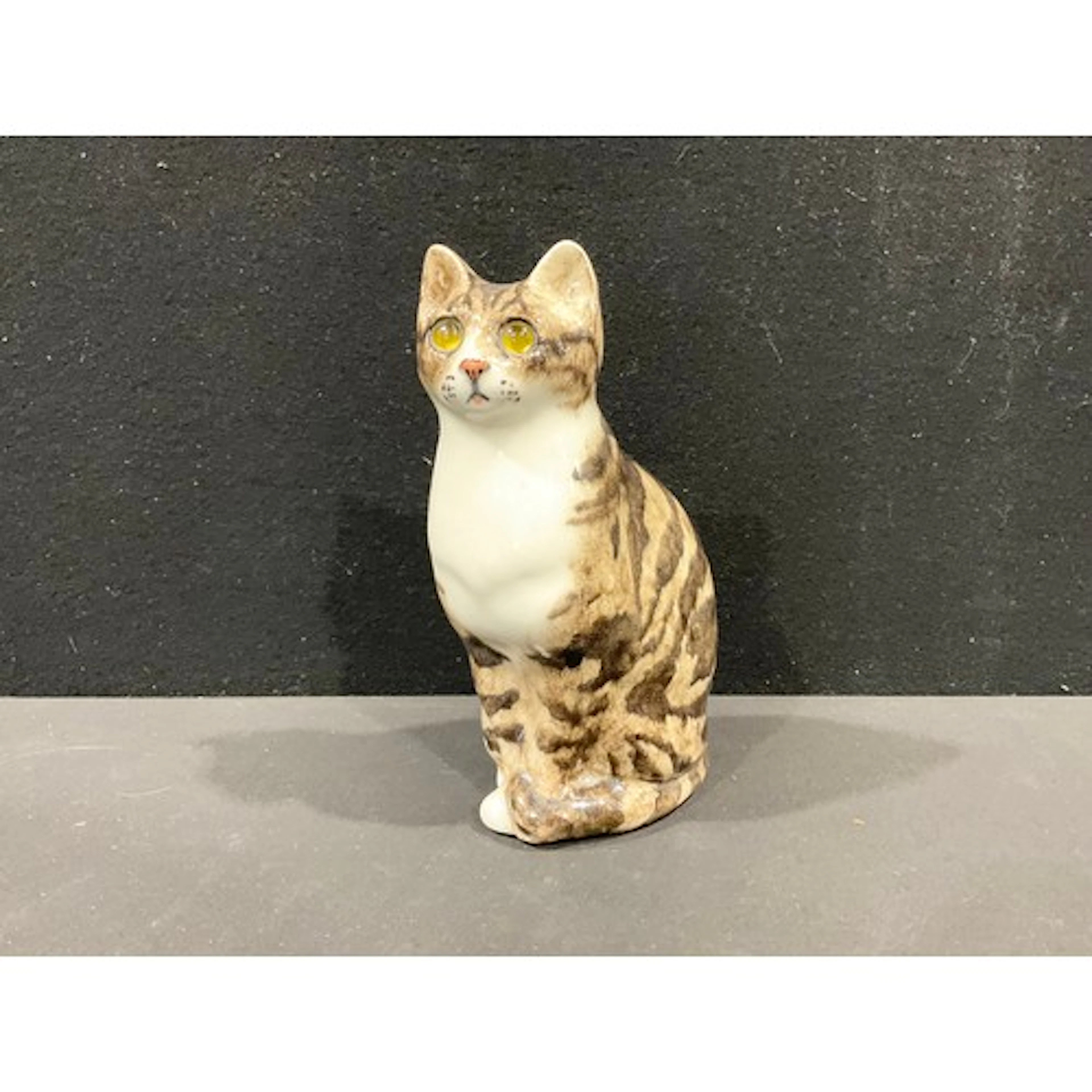 A Winstanley pottery figurine, seated tabby cat, painted fea...