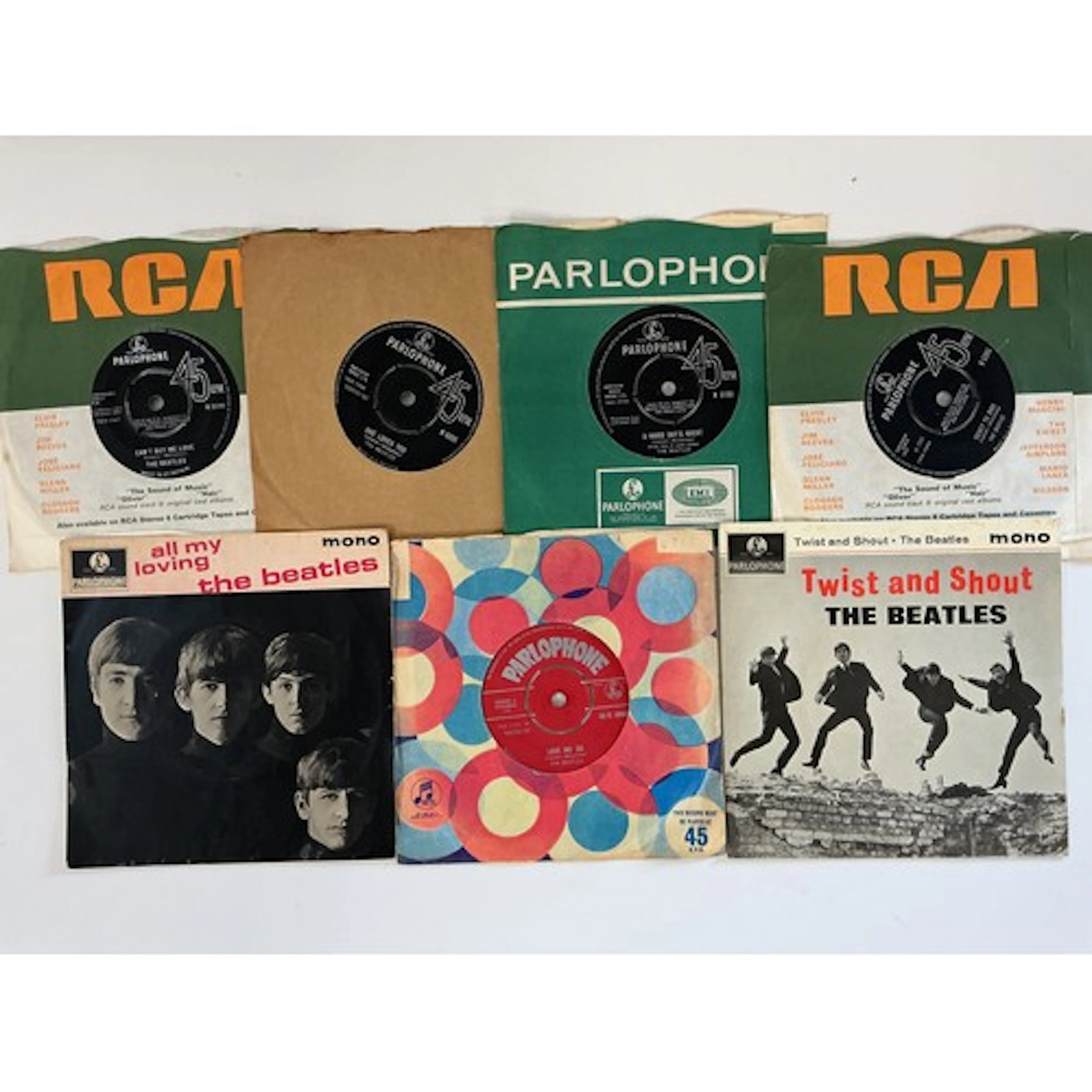 A collection of Beatles 7” singles and EPs including a red l...