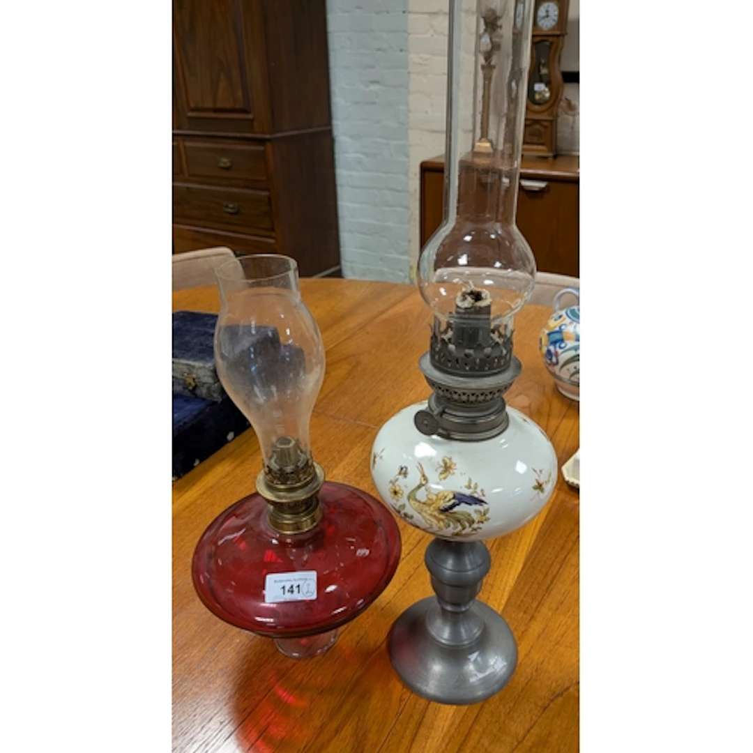 An oil lamp with china bowl on pewter base and a cranberry g...