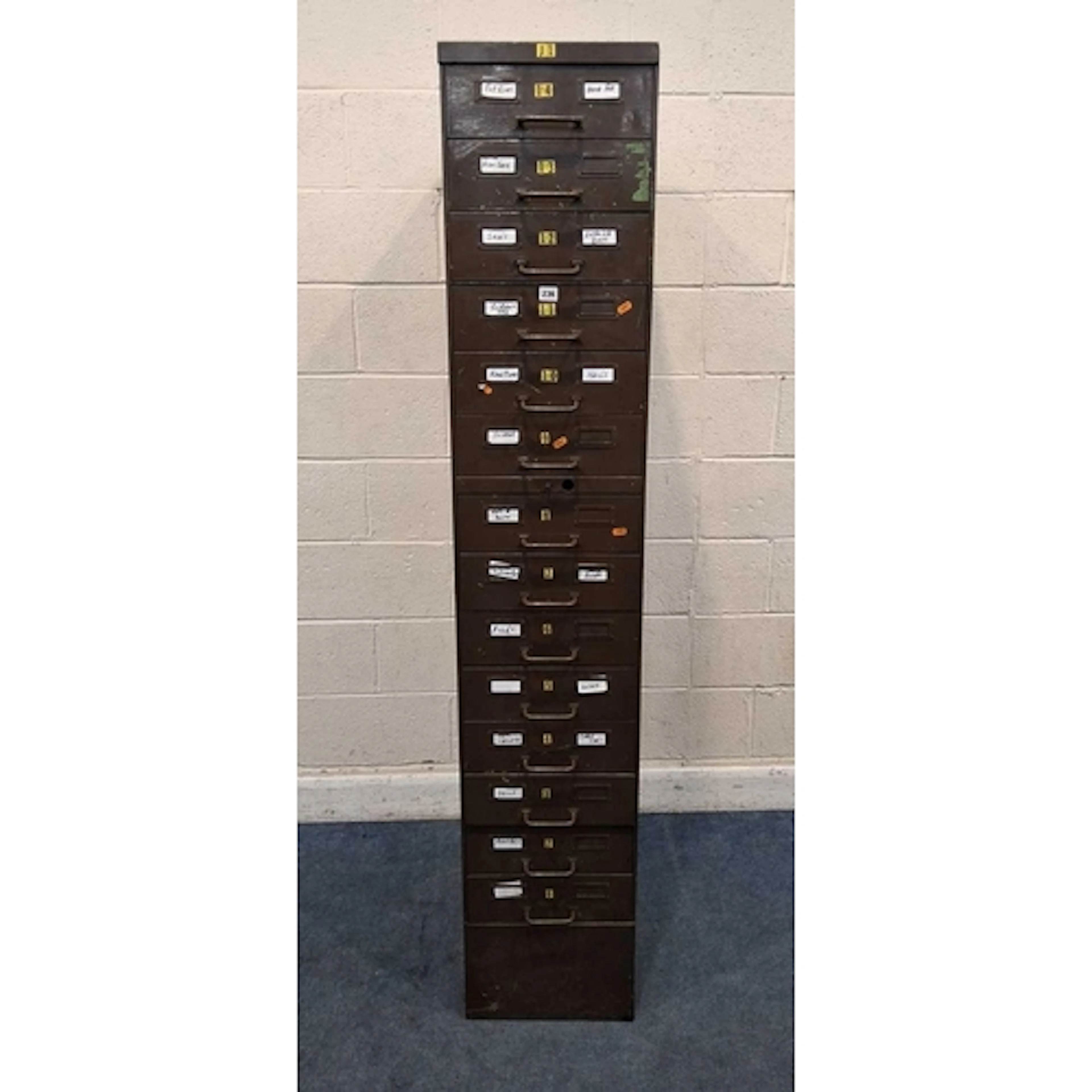 A TALL SLIM INDUSTRIAL METAL FILING CABINET, with fourteen d...