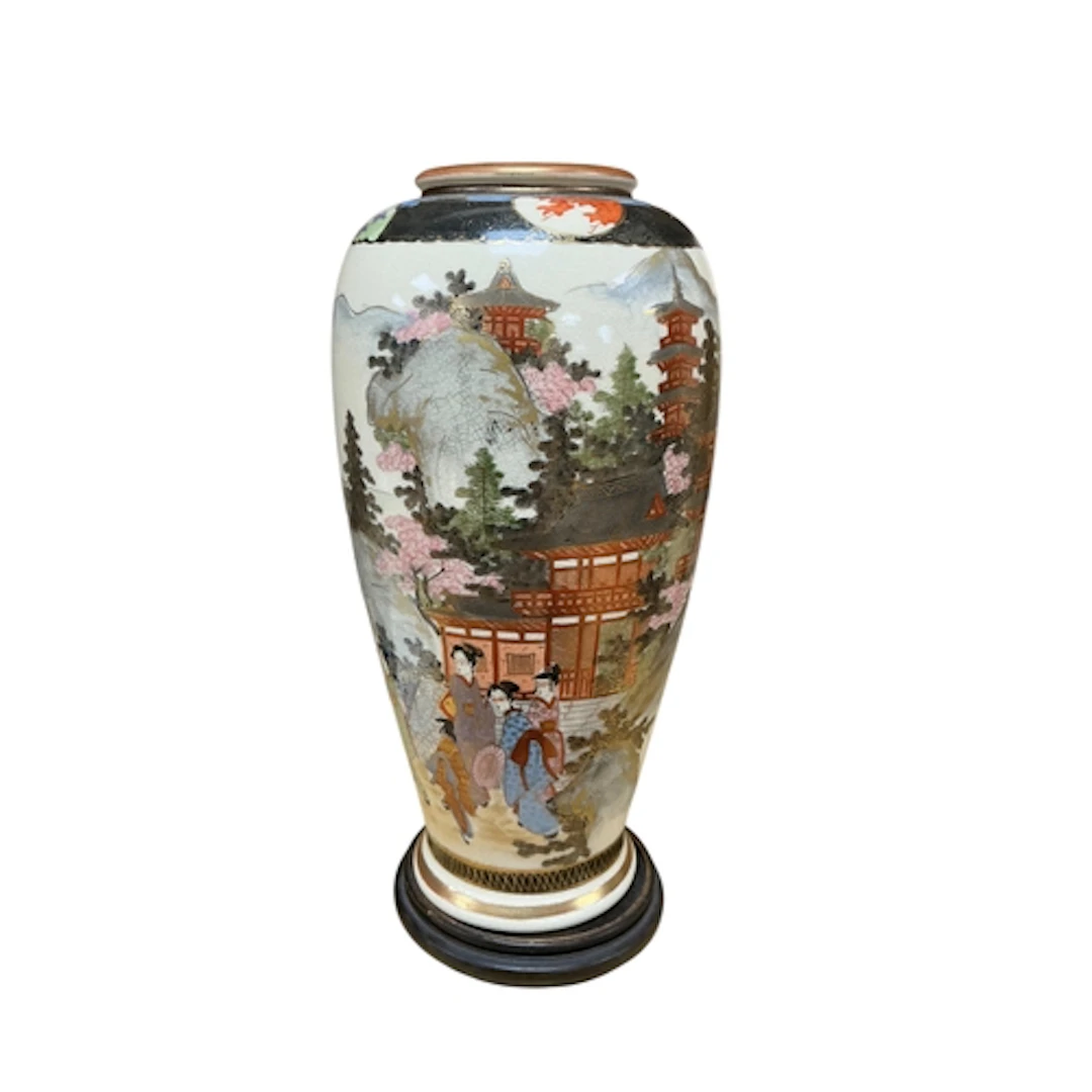 A Japanese Satsuma vase decorated with figures before a pago...