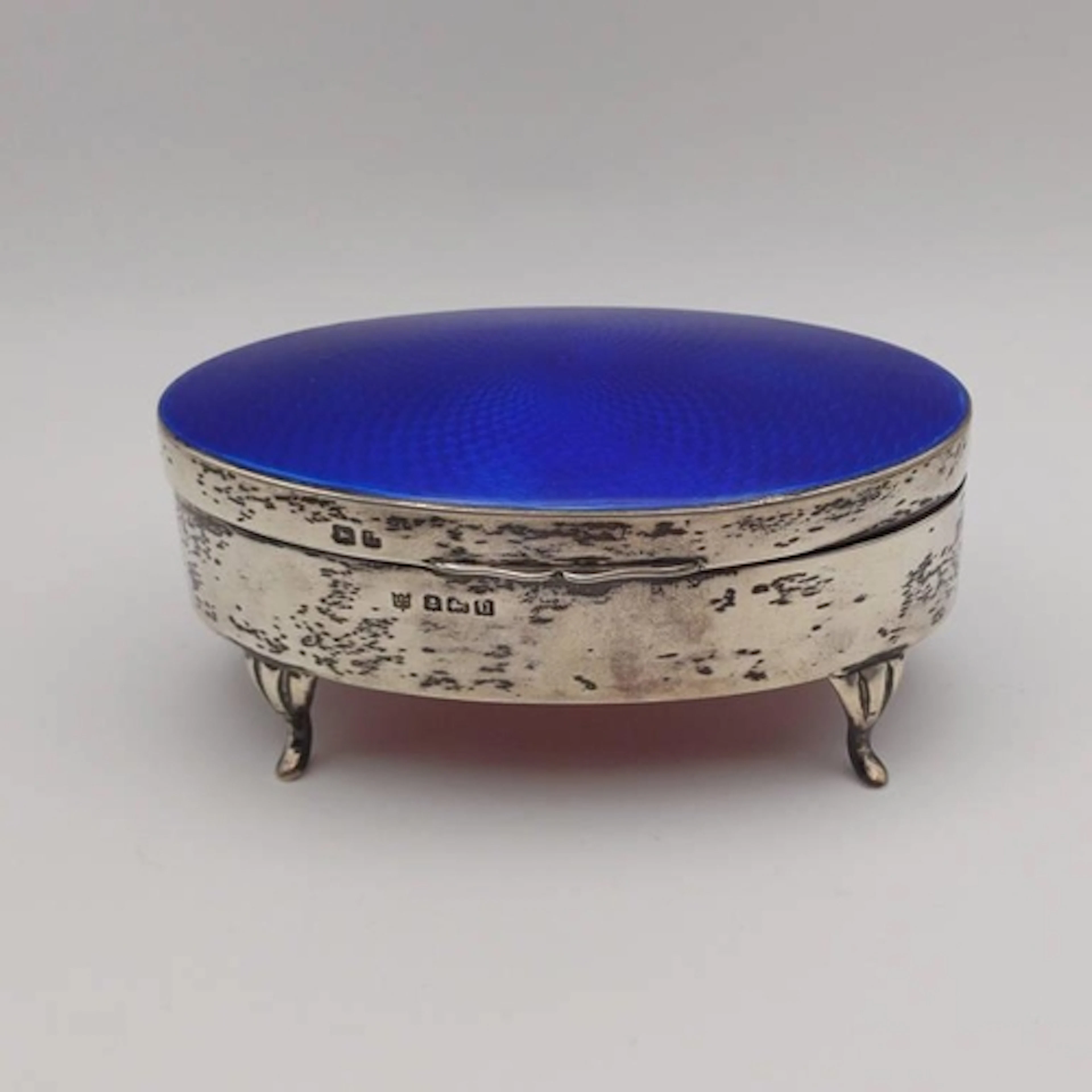 AN OVAL SILVER & ENAMEL JEWELLERY BOX, THE HINGED LID TOPPED...