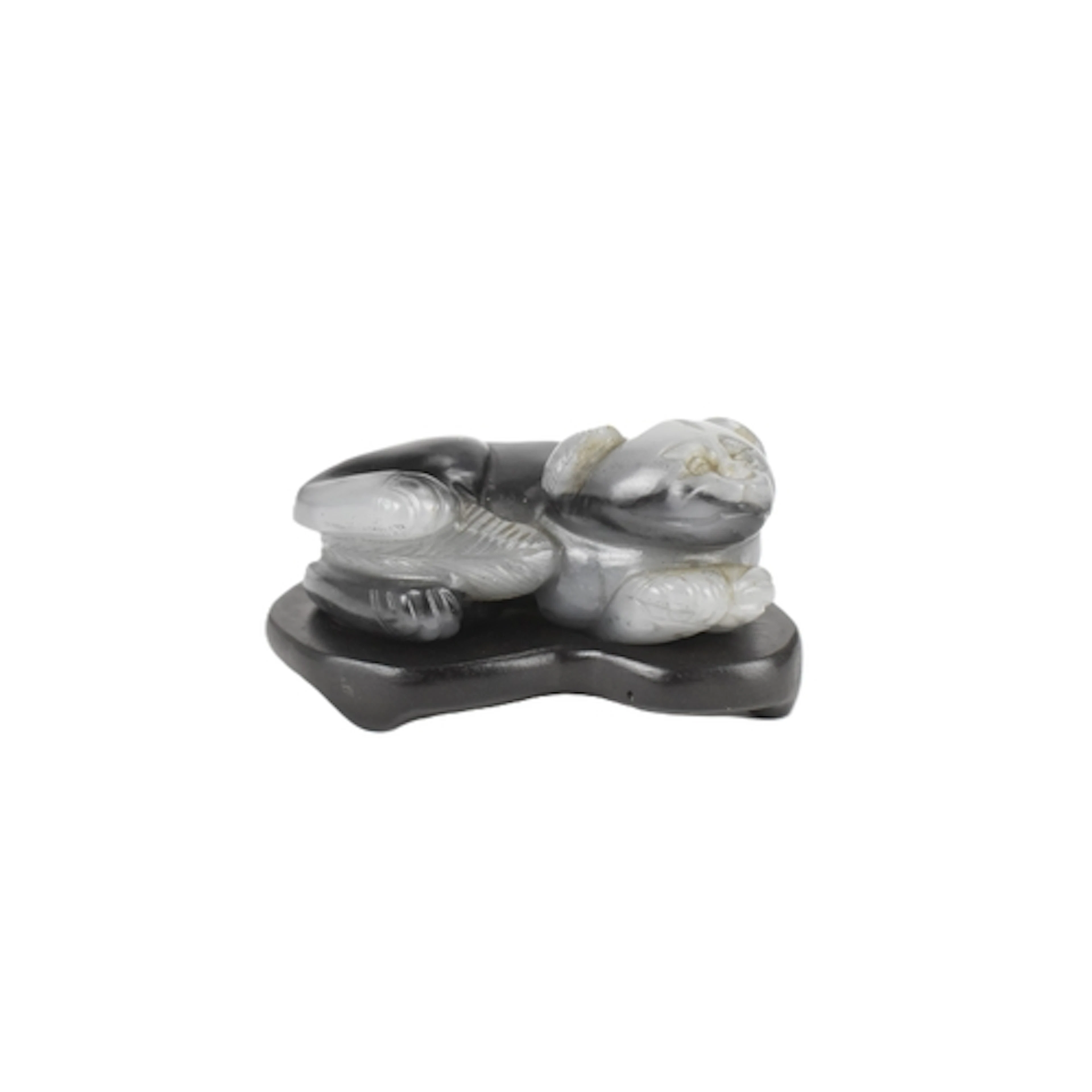 A Chinese black and grey jade carving of a recumbent Buddhis...