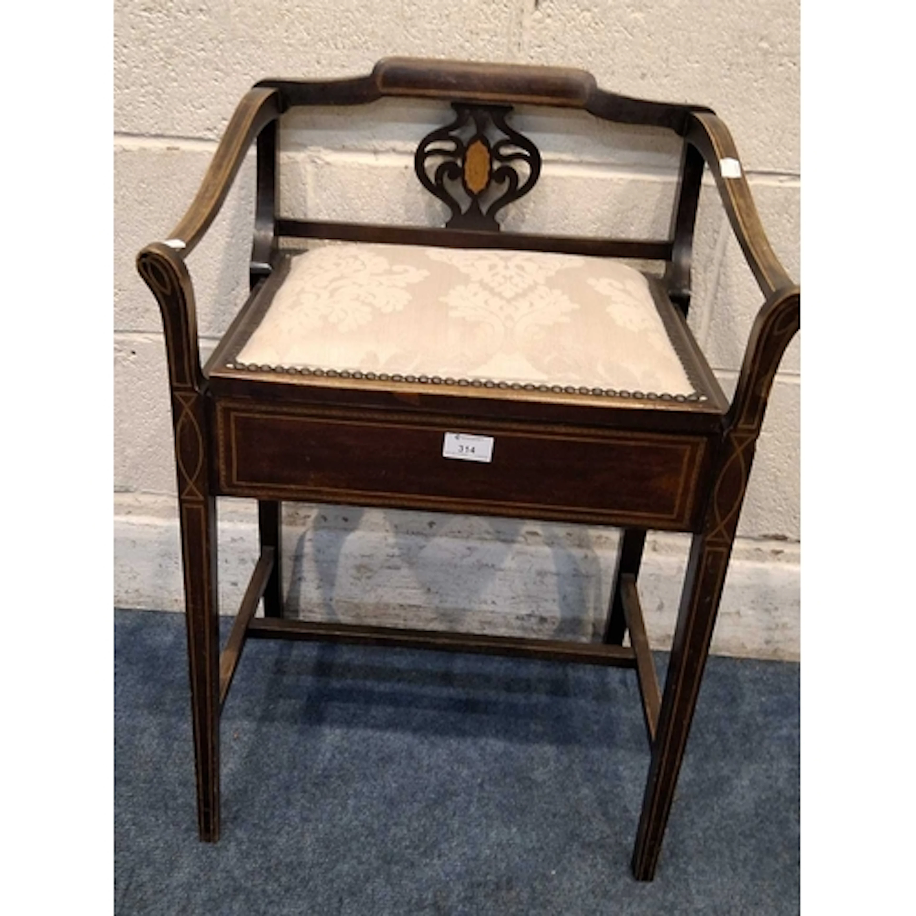 AN EDWARDIAN MAHOGANY PIANO STOOL, with a hinged lid, raised...