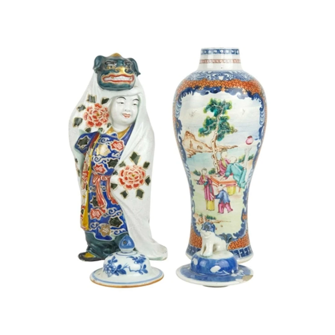 A Japanese porcelain figure of a child wearing a cloak with ...